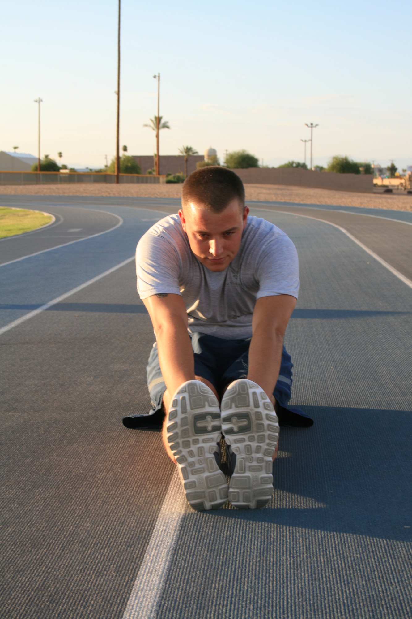 Senior Airman Anthony Holochwost, 756th Aircraft Maintenance Squadron
crew chief, demonstrates a sitting hamstring stretch at the Luke Air Force Base
track, which helps to increase flexibility in the hamstrings.. (U.S. Air Force Photo by Airman 1st Class Grace Lee)