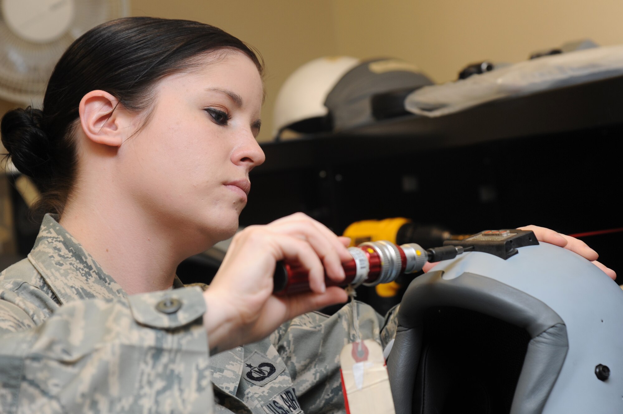 Staff Sgt. Renee Converse, 56th Operations Support Squadron Aircrew Flight Equipment craftsman, torques the set screws to finish installing the upper helmet vehicle interface at the Aircrew Flight Equipment back shop. (U.S. Air Force photo by Senior Airman Sandra Welch)