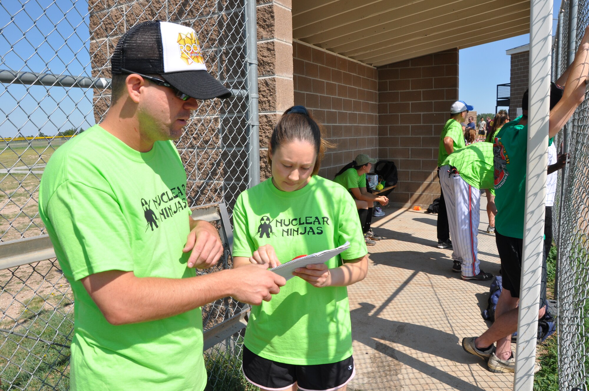 Tech. Sgts. Gabriel Lieber and Jennifer Sherman look at the books to decipher the next strategic move for the Nuclear Ninjas during the Senior Noncommissioned Officer Induction Ceremony Softball Tournament Aug. 4. (U.S. Air Force photo by Capt. Angela Webb)
