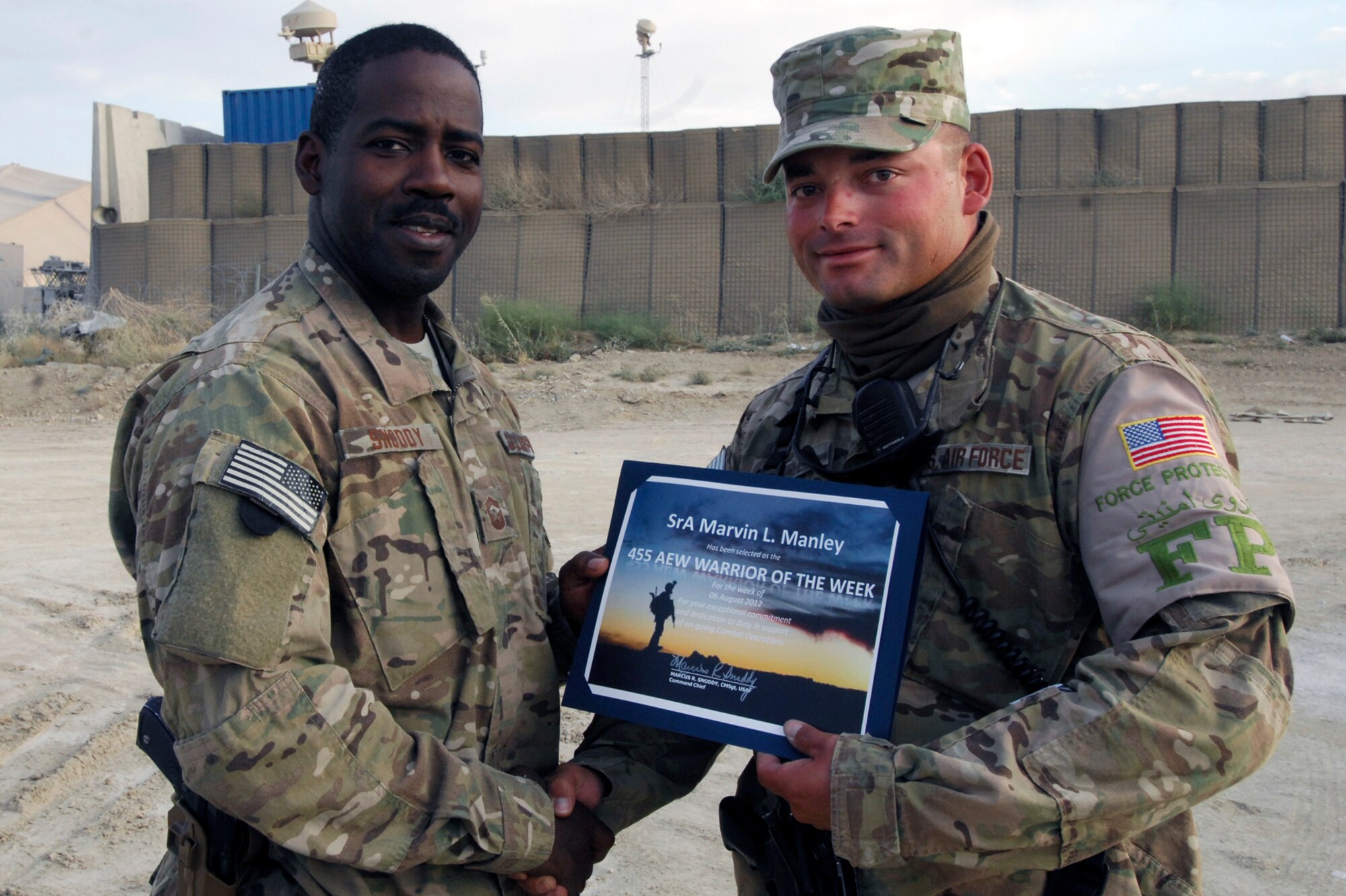 CMSgt Marcus Snoddy, 455th Air Expeditionary Wing command chief, presents the Warrior of The Week certificate to SrA Marvin Manley, 455th Expeditionary Civil Engineer Squadron Force Protection escort, at Bagram Airfield, Afghanistan, Aug. 10, 2012. Manley escorts local nationals, foreign civilian employees and contractors who work on base. (U.S. Air Force photo/SSgt Jeff Nevison)
