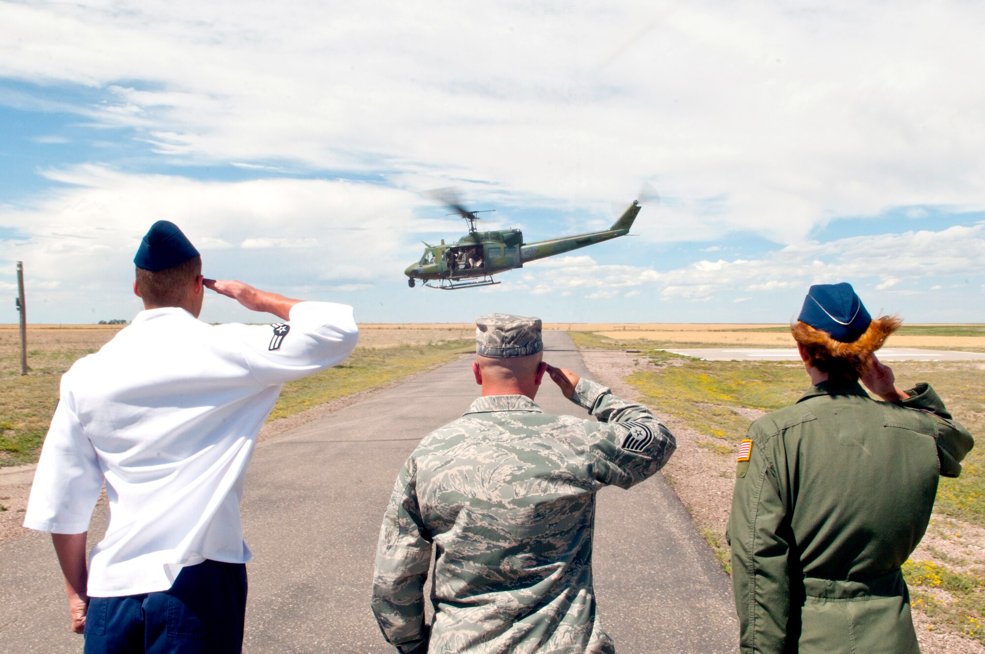 Airman 1st Class Michael Mitchell, 319th Missile Squadron chef, Tech. Sgt. Brandon Fetterer, 319th MS facility manager, and Lt. Col. Catherine Barrington, 319th MS commander, salute the UH-1N Bell helicopter carrying Navy Vice Adm. Timothy M. Giardina, U.S. Strategic Command deputy commander, Col. Christopher Coffelt, 90th Missile Wing commander, Col. Donald Holloway, 90th Operations Group commander, and others as it departs from the missile alert facility they toured July 31. Giardina’s visit to the MAF was a part of his tour of F. E. Warren Air Force Base, Wyo., and its assets. (U.S. Air Force photo by Airman 1st Class Jason Wiese)

