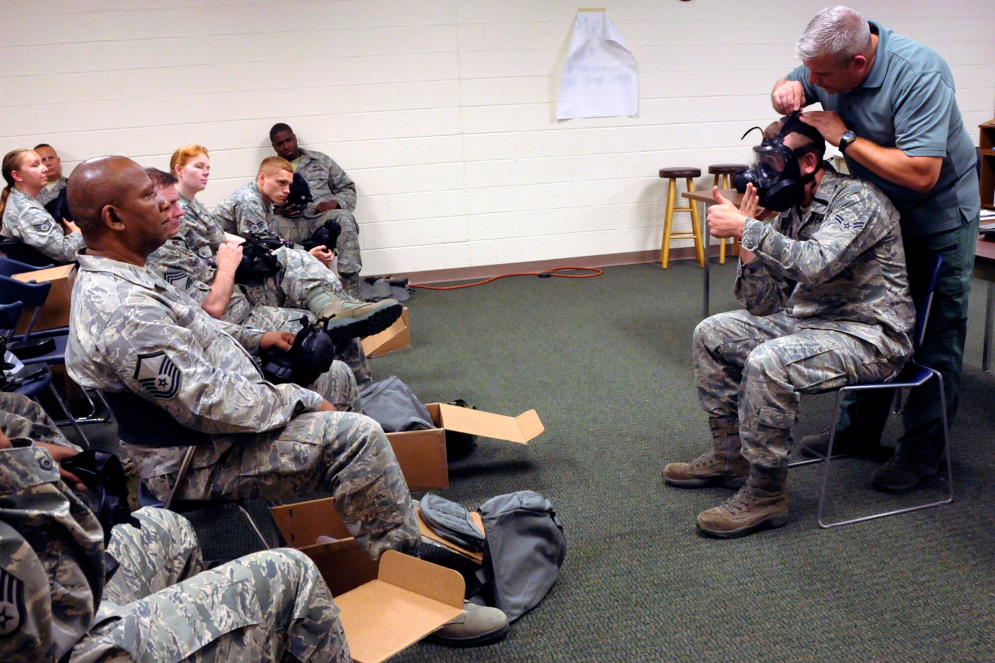 Instructor Mark Kaufmann, a civilian contractor who is also a member of the 127th Wing, demonstrates the proper wear and use of a M-50 Joint Service General Purpose Mask during a training session at Selfridge Air National Guard Base, Mich., Aug. 8, 2012. The mask is being issued to all Air Force personnel, replacing an early version gas mask. The new mask improves air flow and visibility for the wearer. (Air National Guard photo by Brittani Baisden)