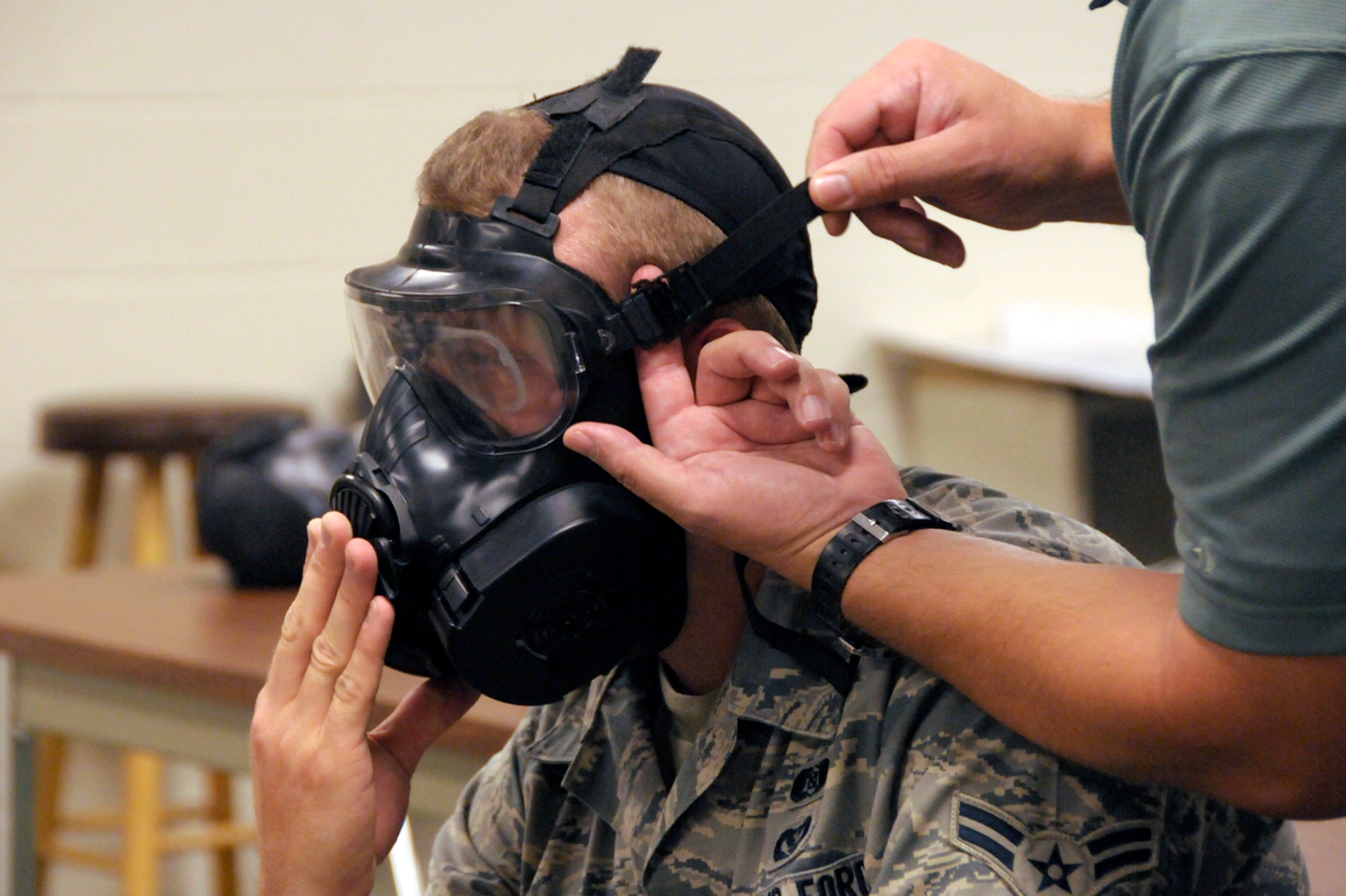 An instructor checks the fit of a new M-50 Joint Service General Purpose Mask on an Airman during a training session at Selfridge Air National Guard Base, Mich., Aug. 8, 2012. The mask is being issued to all Air Force personnel, replacing an early version gas mask. The new mask improves air flow and visibility for the wearer. (Air National Guard photo by Brittani Baisden)