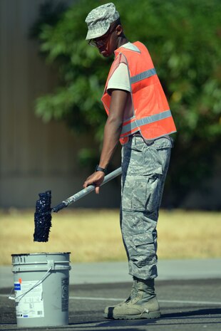 Airman 1st Class Kenneth Robinson, 9th Civil Engineering Squadron, prepares to paint over parking lines on Robert Nicolletti Way near the Beale Lanes bowling alley at Beale Air Force Base, Calif., August 2, 2012. The roadway between the Child Developement Center and Beale Lanes will indefinitely be open to one way traffic to increase safety in the high pedestrian traffic area.  (U.S. Air Force photo by Airman 1st Class Andrew Buchanan)