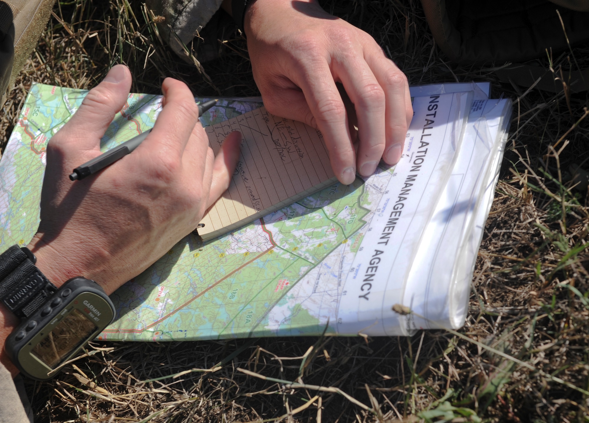 U.S. Air Force Senior Airman Yorke Goddard, 20th Air Support Operations Squadron joint terminal attack controller, writes coordinates during exercise Mountain Peak at Fort Drum, N.Y., July 25, 2012. When guiding aircraft, JTACs use the coordinates to provide an accurate location of targets. (U.S. Air Force photo by Airman 1st Class Douglas Ellis/Released)
