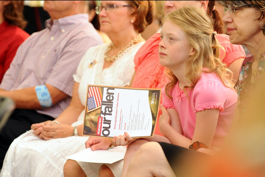 Ten-year-old Evangeline Mason, from Papillion, Neb., attends a ceremony to honor Nebraska’s fallen service members being held at the Bellevue Medical Center, in Bellevue, Neb., Aug. 7.  Evangeline is one of several Nebraska quilters that designed a patch that was used to finish a quilt for the Fallen Heroes Quilt that is presented to the family of the soldier once completed.  (U.S. Air Force photo by Josh Plueger/Released)