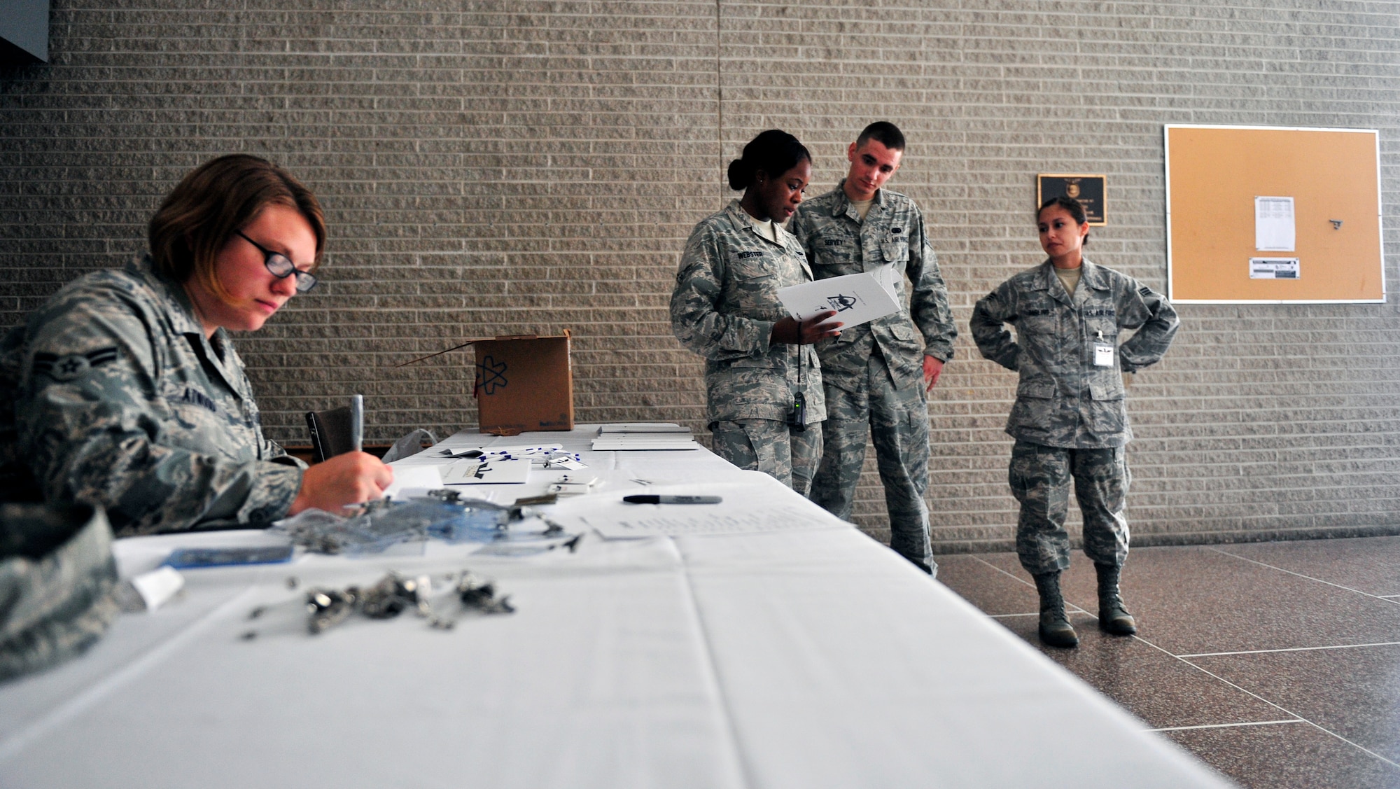 Airmen look over the agenda prior to the opening ceremony of the First Four Airmen Leadership Conference (FALCON) Aug 8, 2012, held on Scott Air Force Base, Ill. The conference, the first of its kind on Scott, was designed for first-term Airmen by first-term Airmen to help them learn networking, professional development and self-improvement skills. The motto for the conference is “Motivate by Duty”.(U.S. Air Force photo/ Staff Sgt. Stephenie Wade) 
