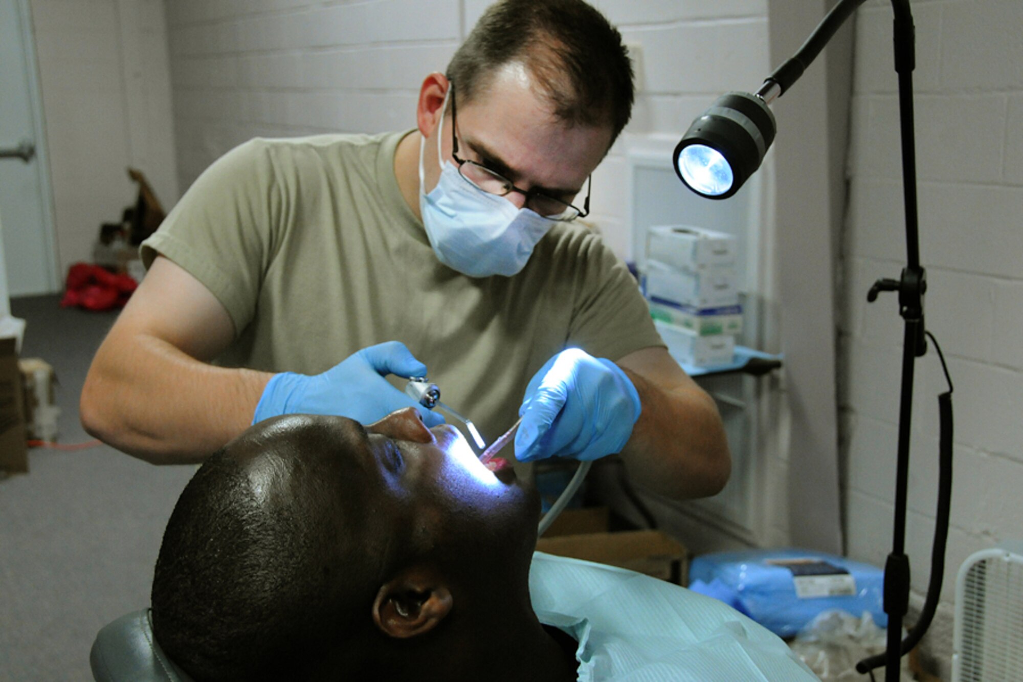 Tech. Sgt. Neal Esplin, 177th Medical Group, New Jersey Air National Guard, provides dental care to an Alabama resident at a Selma medical clinic during the Innovative Readiness Training mission Alabama Care 2012 in Selma, Ala. Aug. 8, 2012. IRT Alabama Care 2012 is an Air National Guard led, multiservice mission comprised of active, reserve, and National Guard members from Army, Navy and Air Force components providing service members with readiness training while providing Alabama residents with free health services such as dental, optometry and medical screenings in the medically underserved and economically depressed community of Selma, Ala. Aug. 7-14, 2012. (National Guard photo by Tech. Sgt. Melissa E. Chatham/RELEASED)