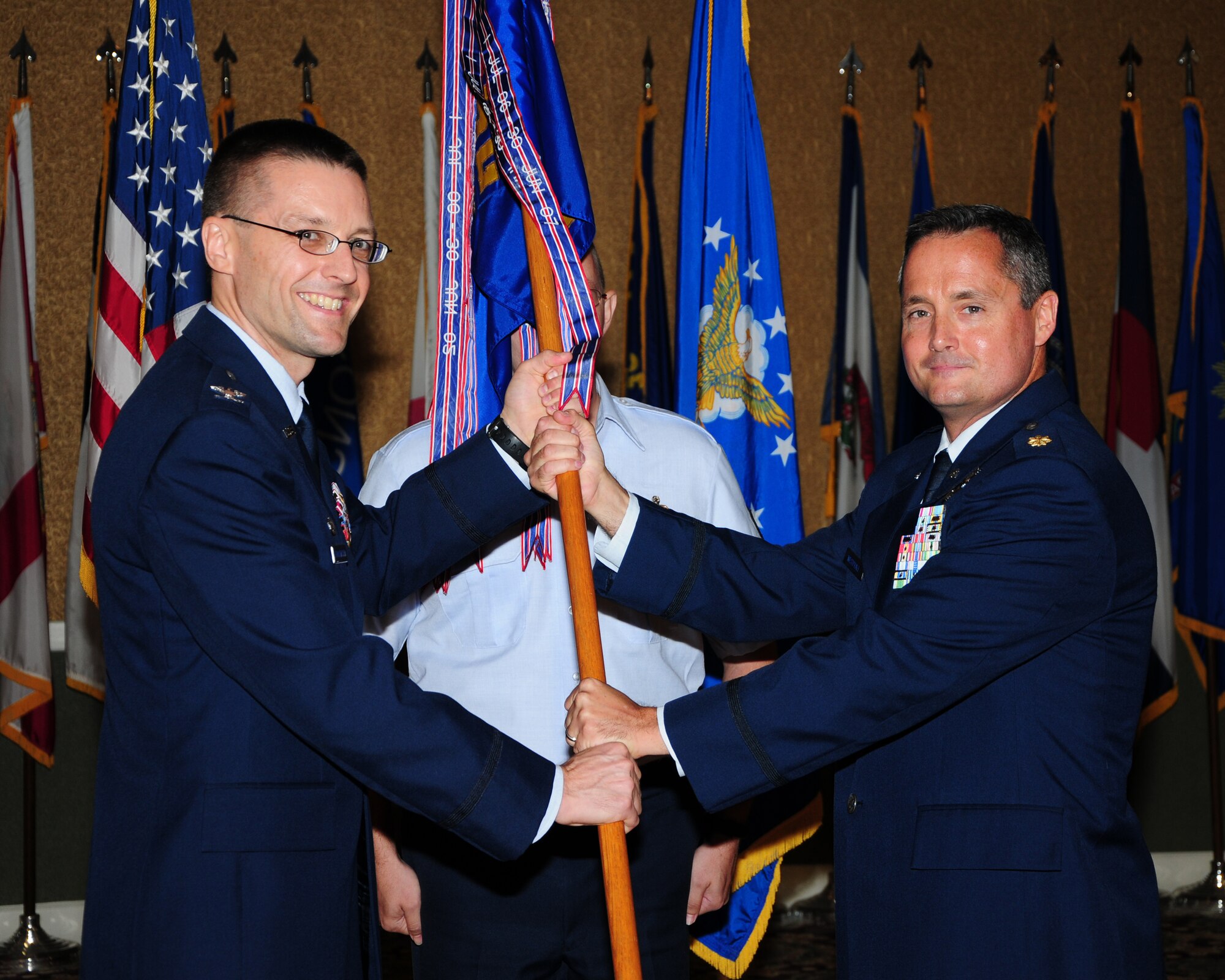 Col. Scott Frickenstein, 14th Mission Support Group Commander hands off the 14th Communications Squadron guidon to Maj. Ingemar Westphall Aug. 6 at the Columbus Club during the 14th CS Assumption of Command ceremony.  The passing of the guidon during the AoC named Westphall the Commander of the 14th CS.  (U.S. Air Force Photo/Melissa Doublin)