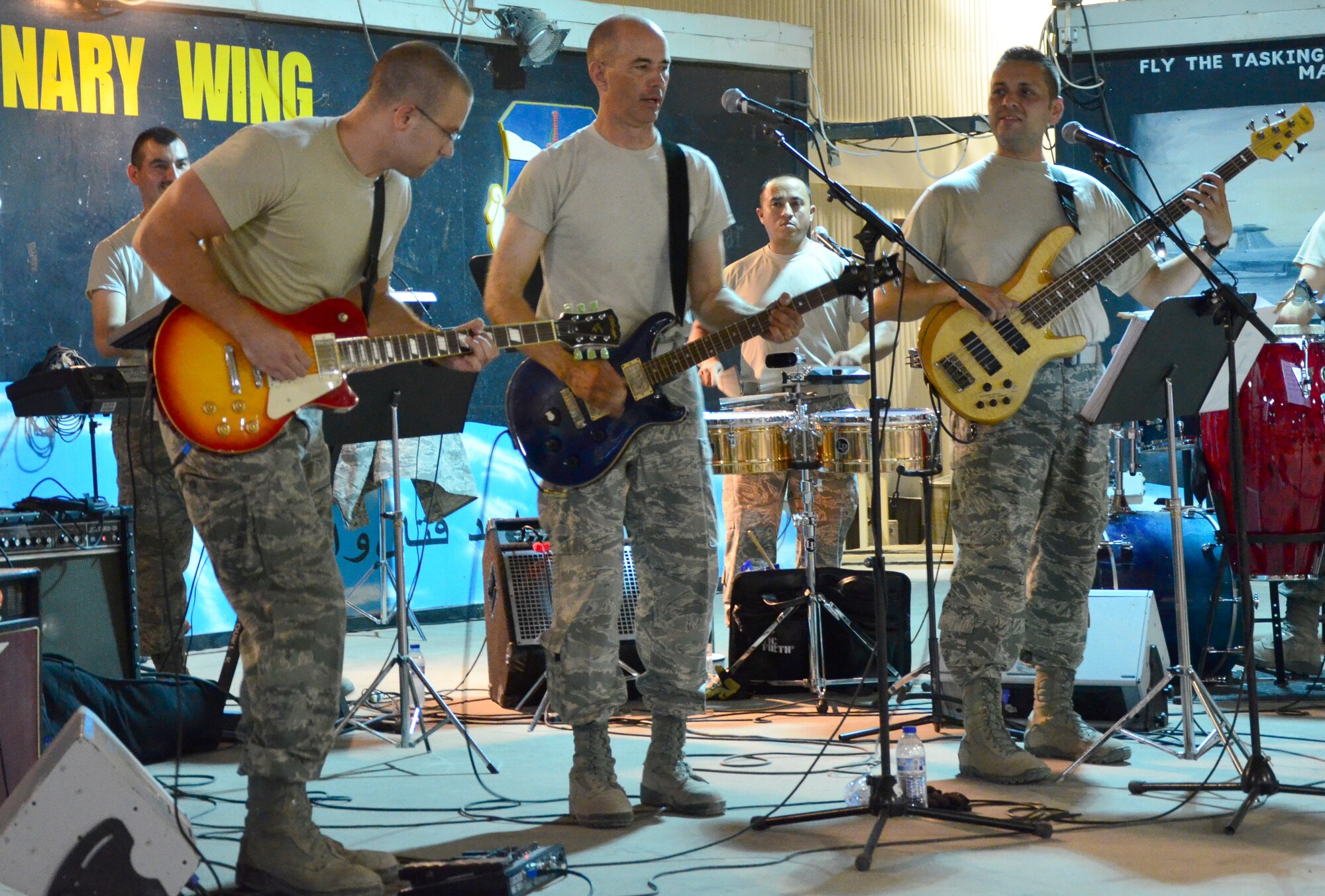 SOUTHWEST ASIA - U.S. Air Force Senior Airman Kenneth Royal, 7th Expeditionary Fighter Squadron member, plays lead guitar along with U.S. Air Forces Central band Vector members Tech. Sgts. Daniel Plaster and Erick Quintanilla during the band's performance at the 380th Air Expeditionary Wing Aug. 8, 2012. Tech. Sgt. Kenneth Hampton, 380th AEW chapel programs NCO in charge, also played drums for a few songs during the band's rock performance Aug. 7. (U.S. Air Force photo/Senior Airman Jared Elliott)