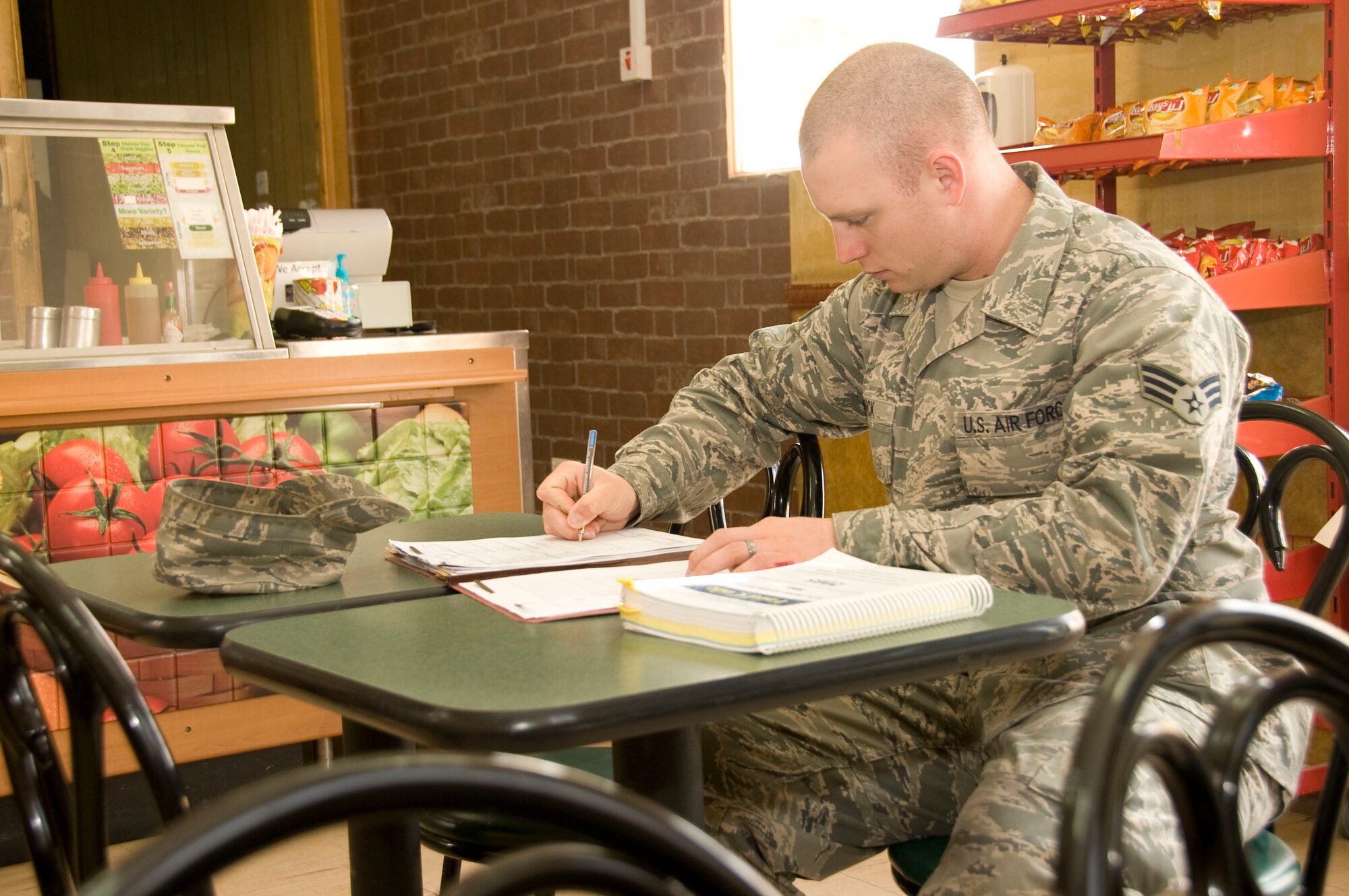 Senior Airman Bryce Dick, 379th Expeditionary Medical Group Public Health community health program manager, writes up his final report after a passing inspection of the Subway on base Aug. 10, 2012. These inspections identify vulnerabilities for intentional or unintentional contamination of the food supply to ensure the base populous remains in good health. Dick is deployed from Aviano Air Base, Italy. (U.S. Air Force photo/Senior Airman Bryan Swink)