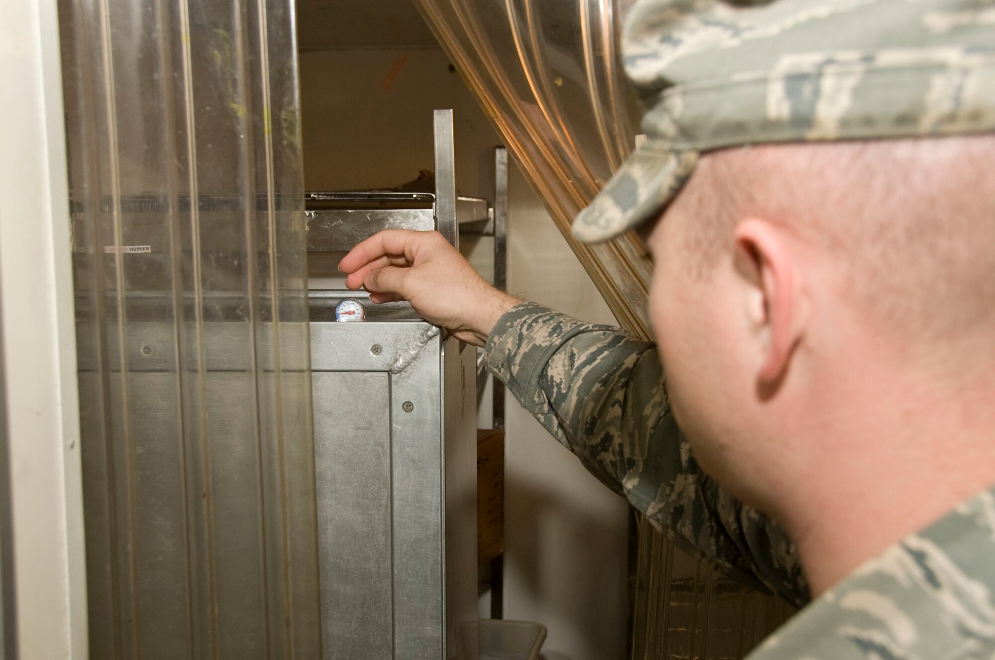 Senior Airman Bryce Dick, 379th Expeditionary Medical Group Public Health community health program manager, checks the temperature of refrigerator at the base Subway during a random health code inspection Aug. 10, 2012. These inspections are in place to ensure the dining facilities on base are adhering to standards and the base population remains in good health. Dick is deployed from Aviano Air Base, Italy. (U.S. Air Force photo/Senior Airman Bryan Swink)