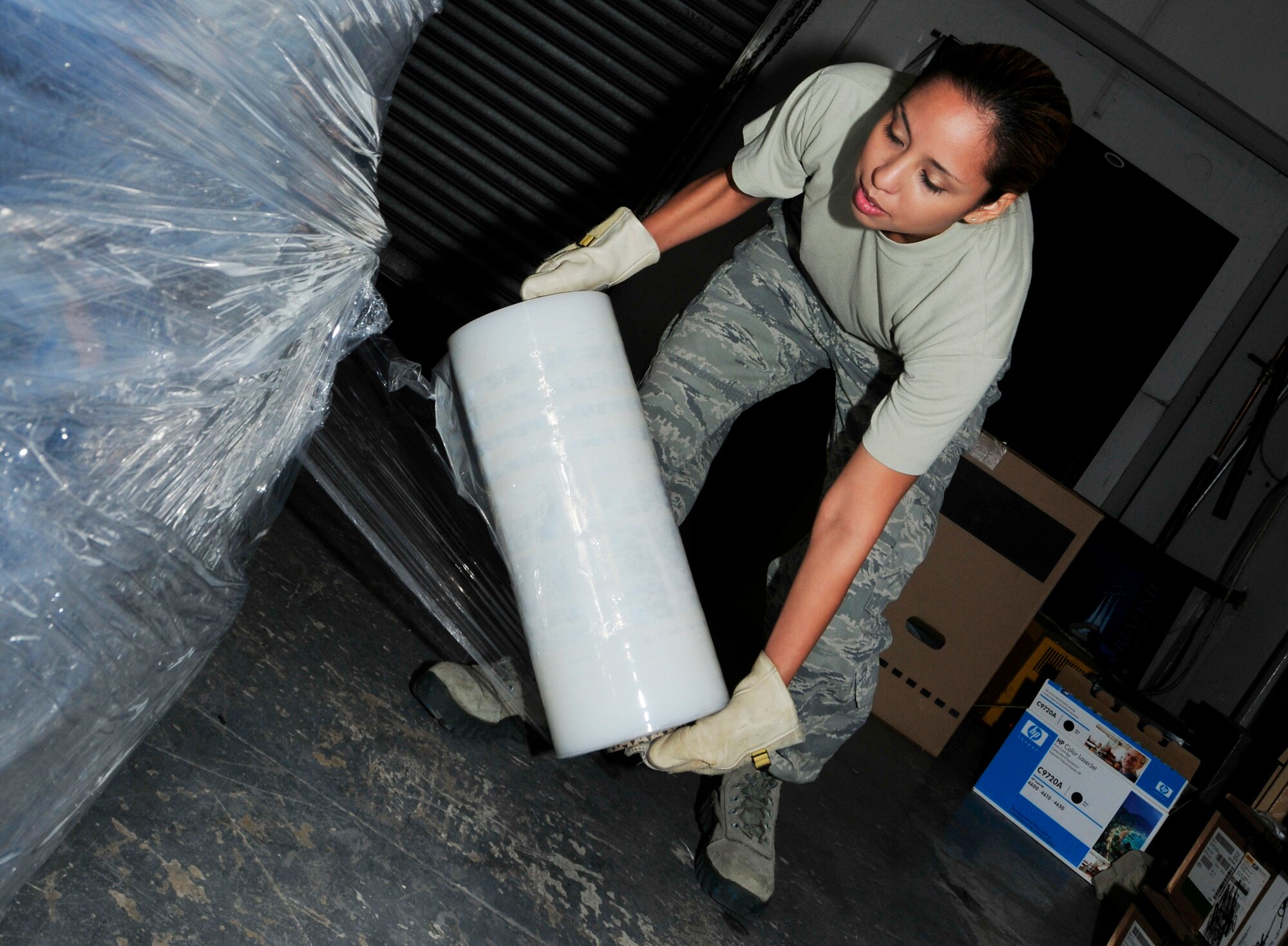 ROYAL AIR FORCE LAKENHEATH, England - Staff Sgt. Gisela Solis, 48th Communications Squadron NCO in charge of asset management wraps a pallet of equipment, August 8, 2012.  Solis was nominated for a Liberty Spotlight because she displays the core value of "Integrity First." (U.S. Air Force photo by Senior Airman Tiffany M. Grigg)