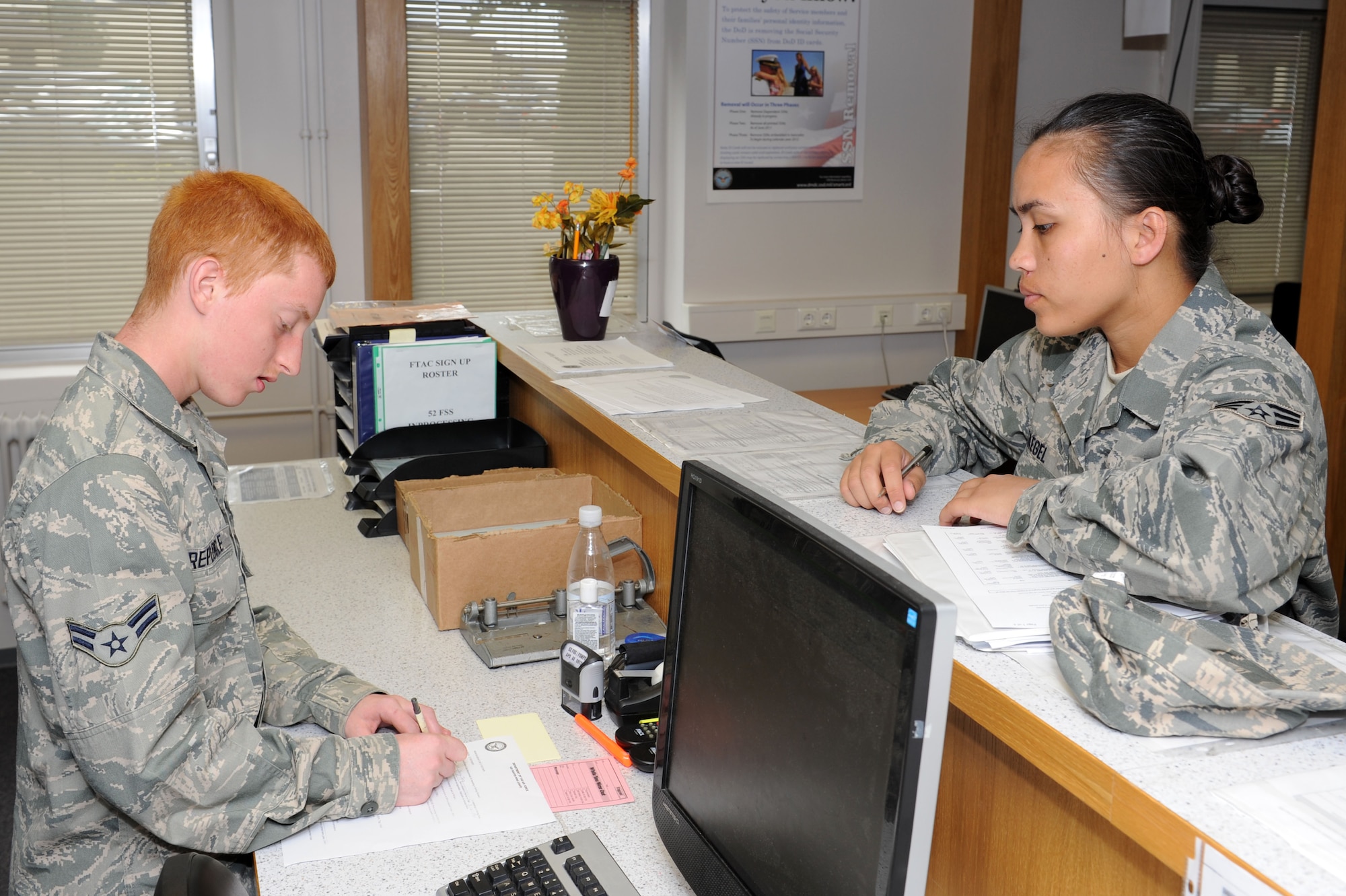 SPANGDAHLEM AIR BASE, Germany – Airman 1st Class Christopher Repogle, 52nd Force Support Squadron customer service technician, helps Senior Airman Jenny Taegel, 52nd Dental Squadron, with enrolling in the defense enrollment eligibility reporting system at the Military Personnel Section here Aug. 8. DEERS is a worldwide, computerized database of uniformed services members, their family members and others who are eligible for military benefits, to include TRICARE. The MPS provides support support to Sabers regarding a number of issues including identification cards, DEERS, Installation Access Control System and more. (U.S. Air Force photo by Senior Airman Christopher Toon/Released)