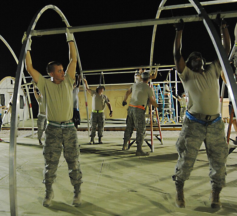 SOUTHWEST ASIA – Col. Joseph Martin, 386th Expeditionary Mission Support Group commander, builds several tents in preparation for inbound and outbound personnel here July 12. For two nights, Airmen from around the wing volunteered their off time to help the eight-man 386th Expeditionary Civil Engineer Squadron structures shop build tents in Commando Village. (U.S. Air Force photo/Staff Sgt. Alexandra M. Boutte)