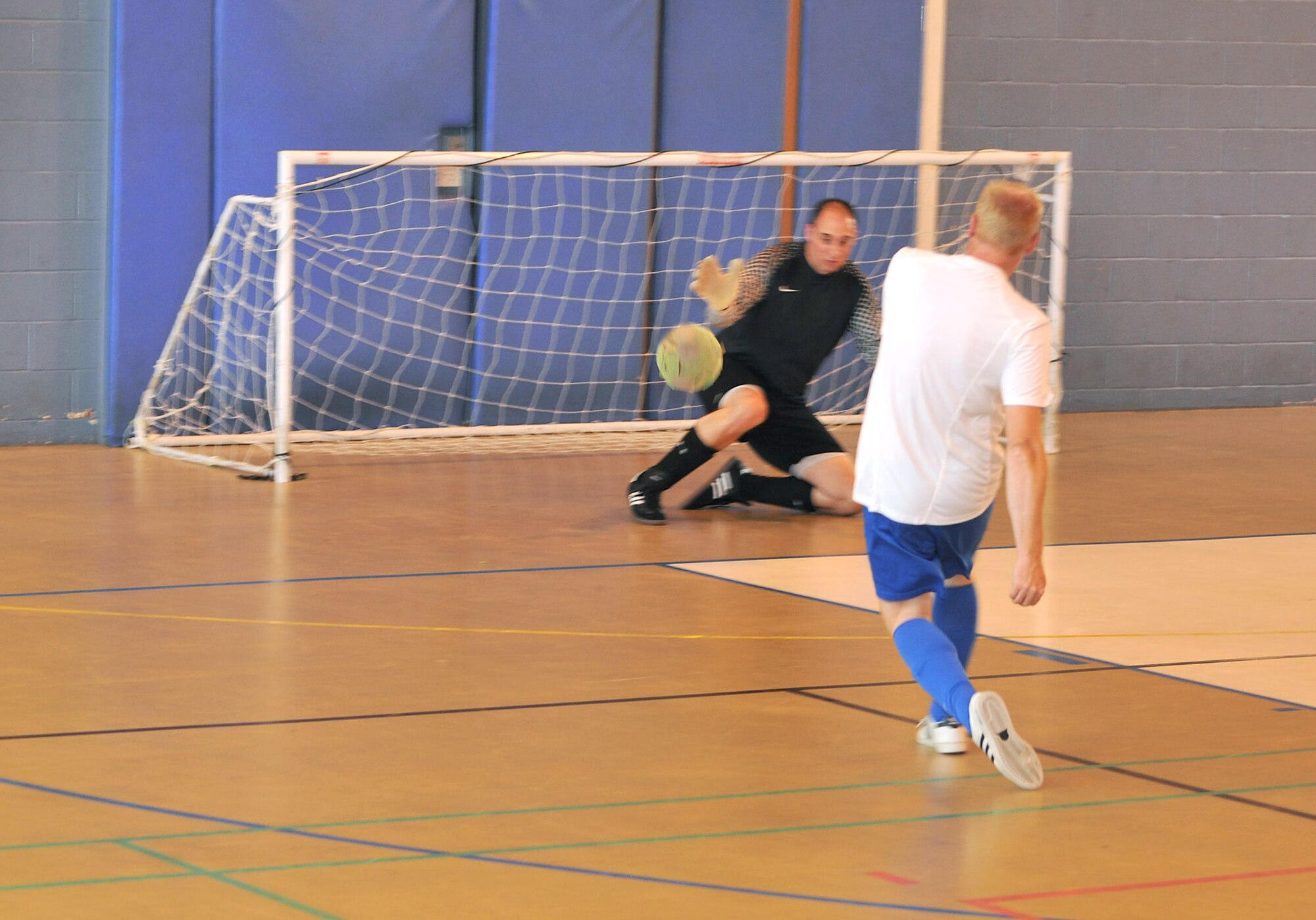 RAF MILDENHALL, England – Martin Parker, 100th Civil Engineer Squadron, takes a shot during the intramural indoor soccer championship game Aug. 9, 2012 at the North Side Fitness Center.  Parker scored two goals in the game against the 100th Maintenance Squadron. (U.S. Air Force photo/Senior Airman Jerilyn Quintanilla)