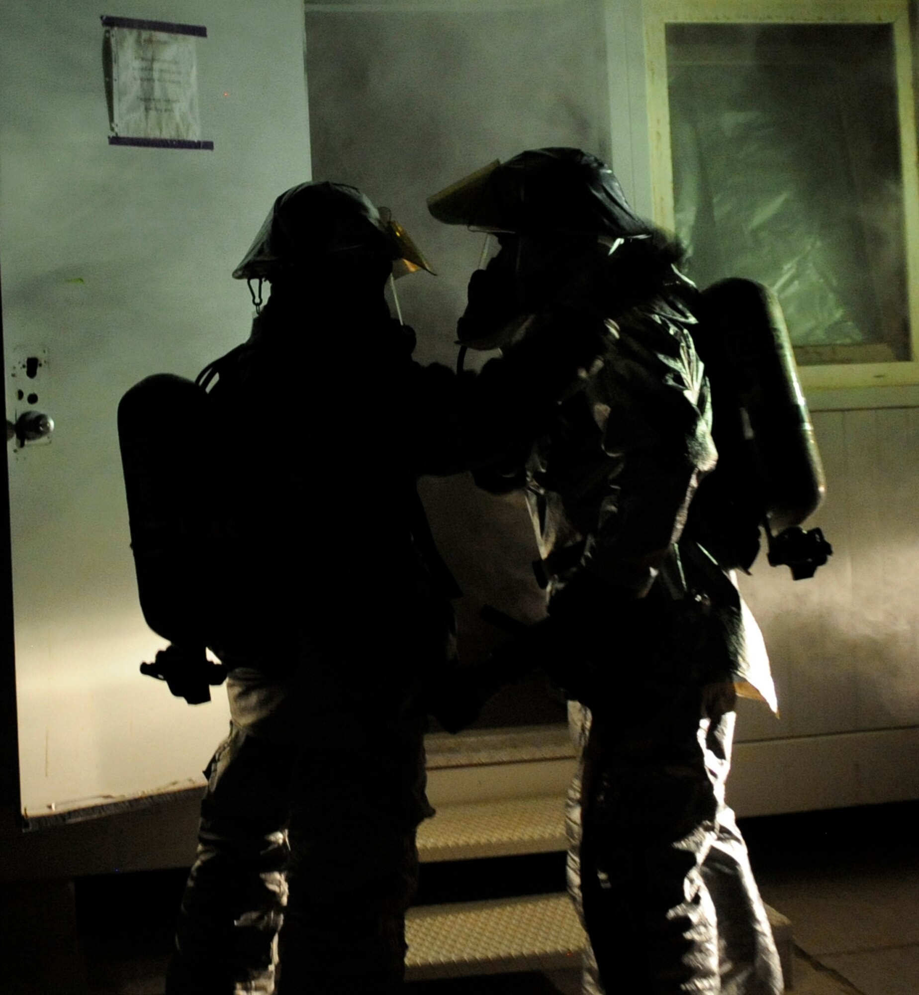 SOUTHWEST ASIA – Two firefighters from the 386th Expeditionary Civil Engineer Squadron, prepare to enter a building full of smoke to look for potential victims during a practical exercise here August 7. The scenario-based exercise was a simulated vehicle versus building incident. This particular scenario was a certification course that provided a real-world scenario to a fire fighter who is moving up in the ranks to be a crew chief of a fire apparatus. This exercise gave the fire fighter a chance to make the decisions that would need to be made when faced with an emergency. (U.S. Air Force photo/Staff Sgt. Alexandra M. Boutte)