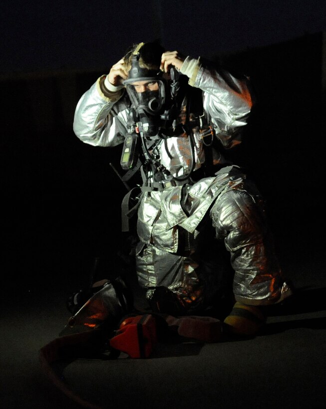 SOUTHWEST ASIA – Staff Sgt. James Michalisko, 386th Expeditionary Civil Engineer Squadron fire firefighter, dons his self-contained breathing apparatus in preparation to enter a smoking building during an exercise here August 7. Firefighters use protective gear to shield themselves from open flame and the temperature from the smoke. The fire fighters will also bring a tool such as an ax or a halogen bar if there’s a possibility of forcible entry. (U.S. Air Force photo/Staff Sgt. Alexandra M. Boutte)
