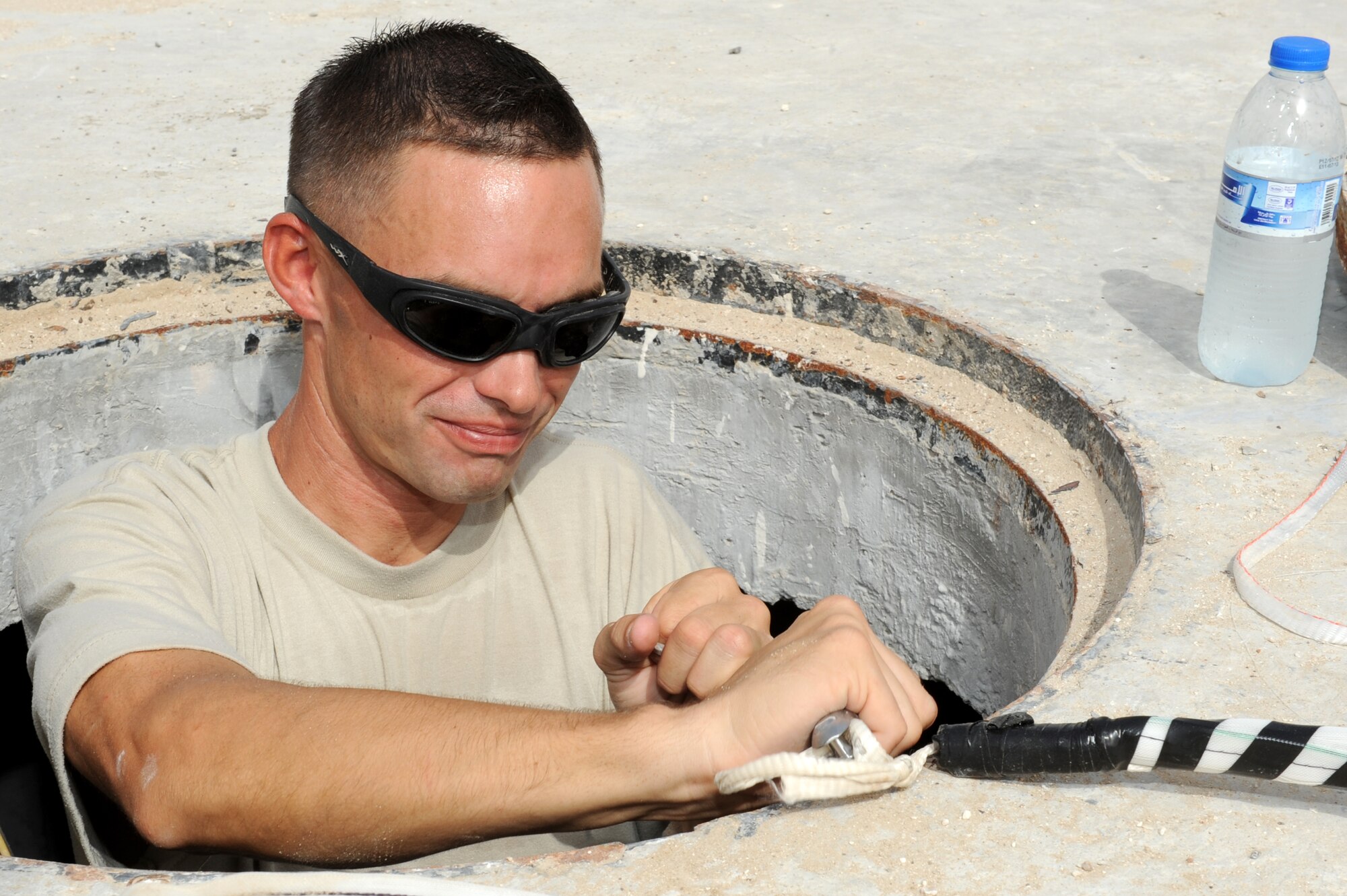 SOUTHWEST ASIA - U.S. Air Force Staff Sgt. David Hollars, 380th Expeditionary Communications Squadron cable TV NCO in charge, ties a line to run cable underground Aug. 8, 2012. Hollars, a Mitchell, Ind., native, is deployed to the 380th Air Expeditionary Wing from Kadena Air Base, Japan.(U.S. Air Force photo/Master Sgt. Scott MacKay)