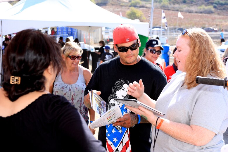 Heather Rogers (right) of Bristol Environmental Remediation Services conducts a short survey with race fans. The tablet based program helps capture what types of off-road activities they participate in on public lands and where they might have seen ordnance. The area is part of the former California-Arizona Maneuver Area, where Gen. George S. Patton, Jr., trained a million troops for desert warfare. 