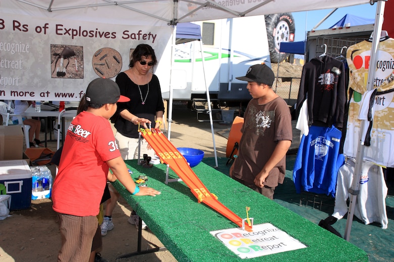 Suneeta Sahgal (center) a Los Angeles District FUDS project manager speaks with young participants about the 3Rs of explosives safety during a Lucas Oil Off Road Racing Series event held at the Glen Helen Raceway in San Bernardino Aug. 4-5. The finish line of the game, fact sheets and prizes reflect the programs key message: Recognize, Retreat and Report.