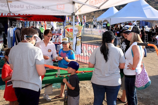 Fran Firouzi (left center) a Los Angeles District FUDS project manager hands a 3Rs of Explosives Safety sticker to a young race fan during a Lucas Oil Off Road Racing Series event held at the Glen Helen Raceway in San Bernardino Aug. 4-5. District program managers and contract partners from Bristol Environmental Remediation Services spoke to off-road fans of all ages during the two-day event.
