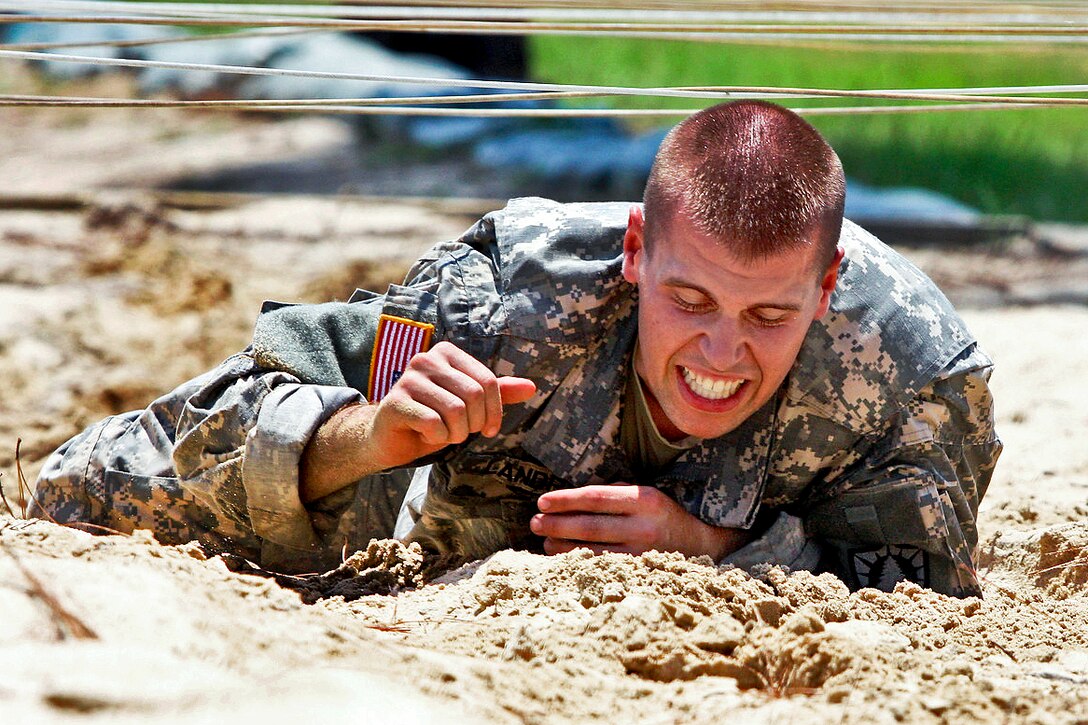 Army Sgt. Matthew Howard crawls over sand under ropes at the Warrior Training Center's obstacle course during the Best Warrior Competition on Fort Benning, Ga., Aug. 1, 2012. Howard, the National Guard Noncommissioned Officer of the Year, is assigned to the Arkansas National Guard. The competition tests soldiers in various areas, such as stress hooting, urban operations, obstacle courses and land navigation.