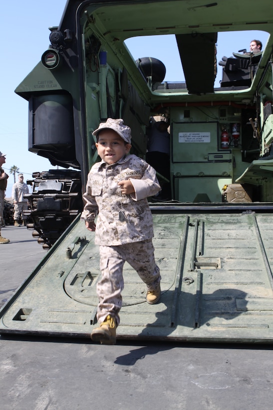 Jorge Solis, 5, runs off an amphibious assault vehicle after taking a ride at 3rd Assault Amphious Battalion during his base tour Aug. 10.