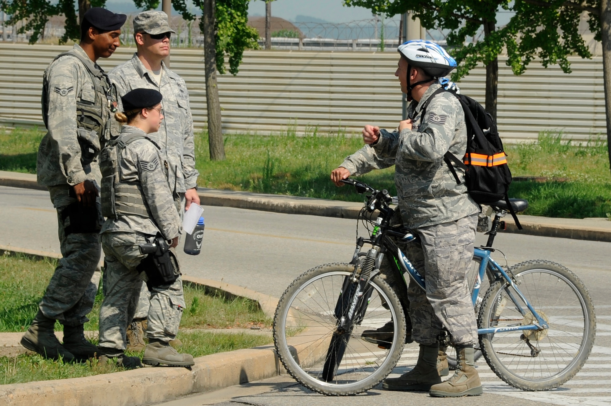 Airman 1st Class Patrick Ward, 8th Security Forces Squadron patrolman, and Staff Sgt. Amanda Everett, 8th SFS assistant flight sergeant, stop an Airman for failing to come to a complete halt at a stop sign while Tech. Sgt. Ryan Armour, 8th Fighter Wing ground safety technician, observes at Kunsan Air Base, Republic of Korea, Aug. 1, 2012. Over the course of one hour, 30 bicyclists traversed the intersection: 17 ran a stop sign, two rode on the sidewalk, and one failed to wear personal protective equipment properly. (U.S. Air Force photo/Senior Airman Marcus Morris)