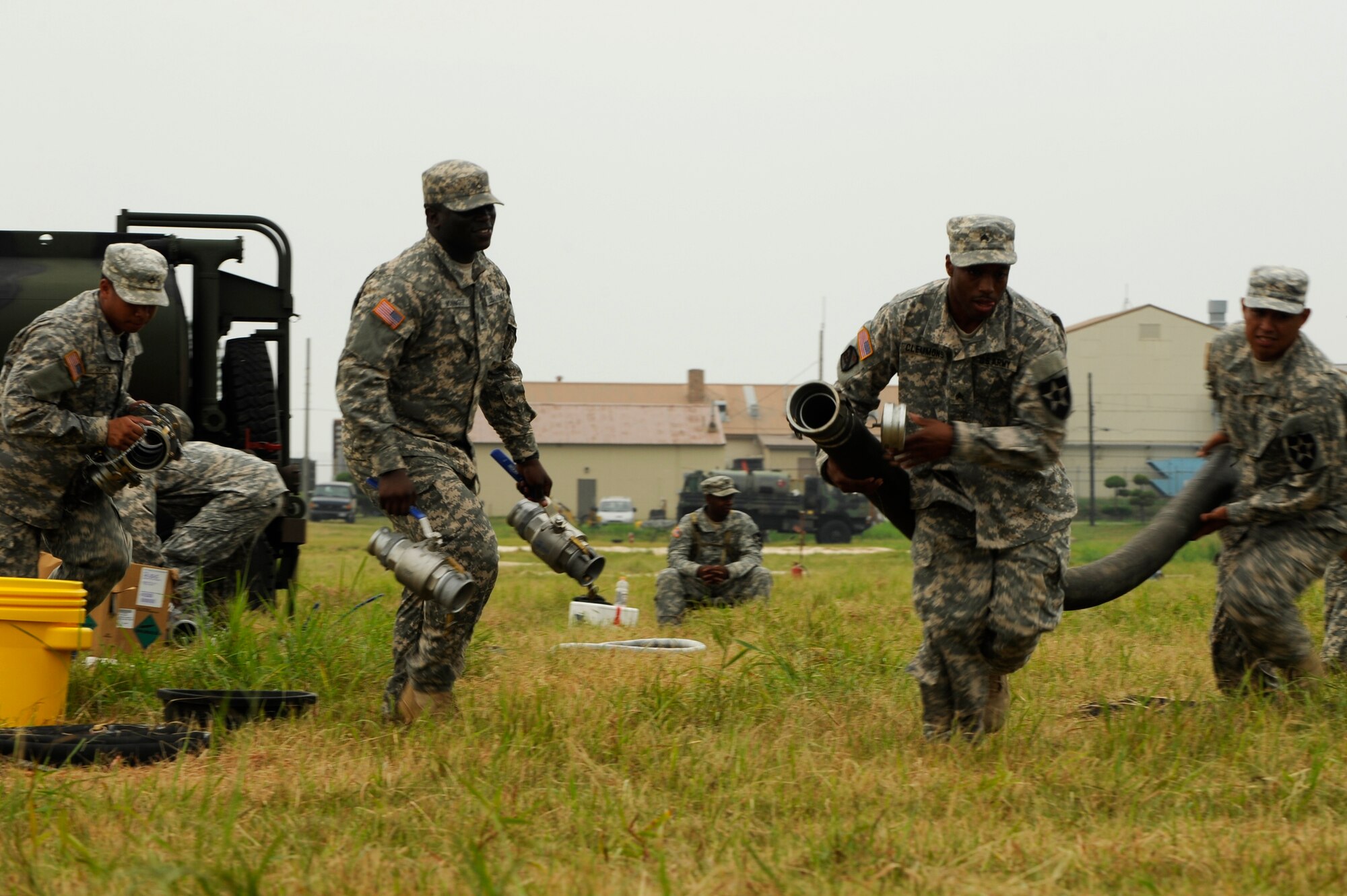 Members of the U.S. Army 602nd Alpha Company, 302nd Brigade Support Battalion, run to set up fuel equipment for a simulated convoy during a Petroleum, Oil, and Lubrication Expo at Kunsan Air Base, Republic of Korea, Aug. 9, 2012. This was the first POL Expo the Army has held to demonstrate their personnel’s wartime capabilities. (U.S. Air Force photo/Senior Airman Marcus Morris)
