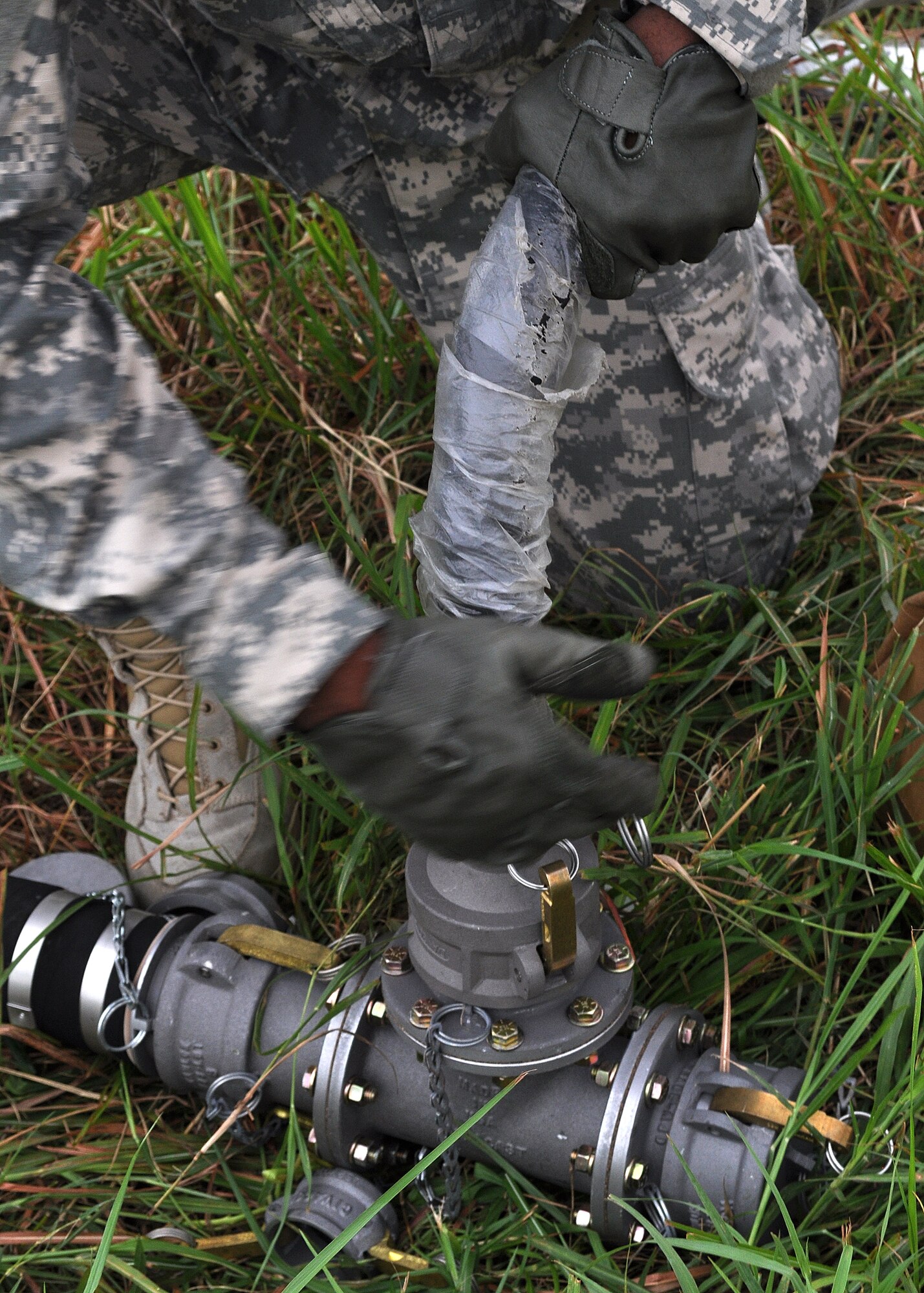 U.S. Army Spc. Olusiji Aderibigbe, A Company 302nd Brigade Support Battalion, attaches a hose to a transfer line during a competition with other U.S. Army personnel on Kunsan Air Base, Republic of Korea, Aug. 9, 2012. This was part of the first Petroleum, Oil and Lubrication Expo that is designed to demonstrate wartime capabilities of POL personnel. (U.S. Air Force photo/Staff Sgt. Jonathan Fowler)