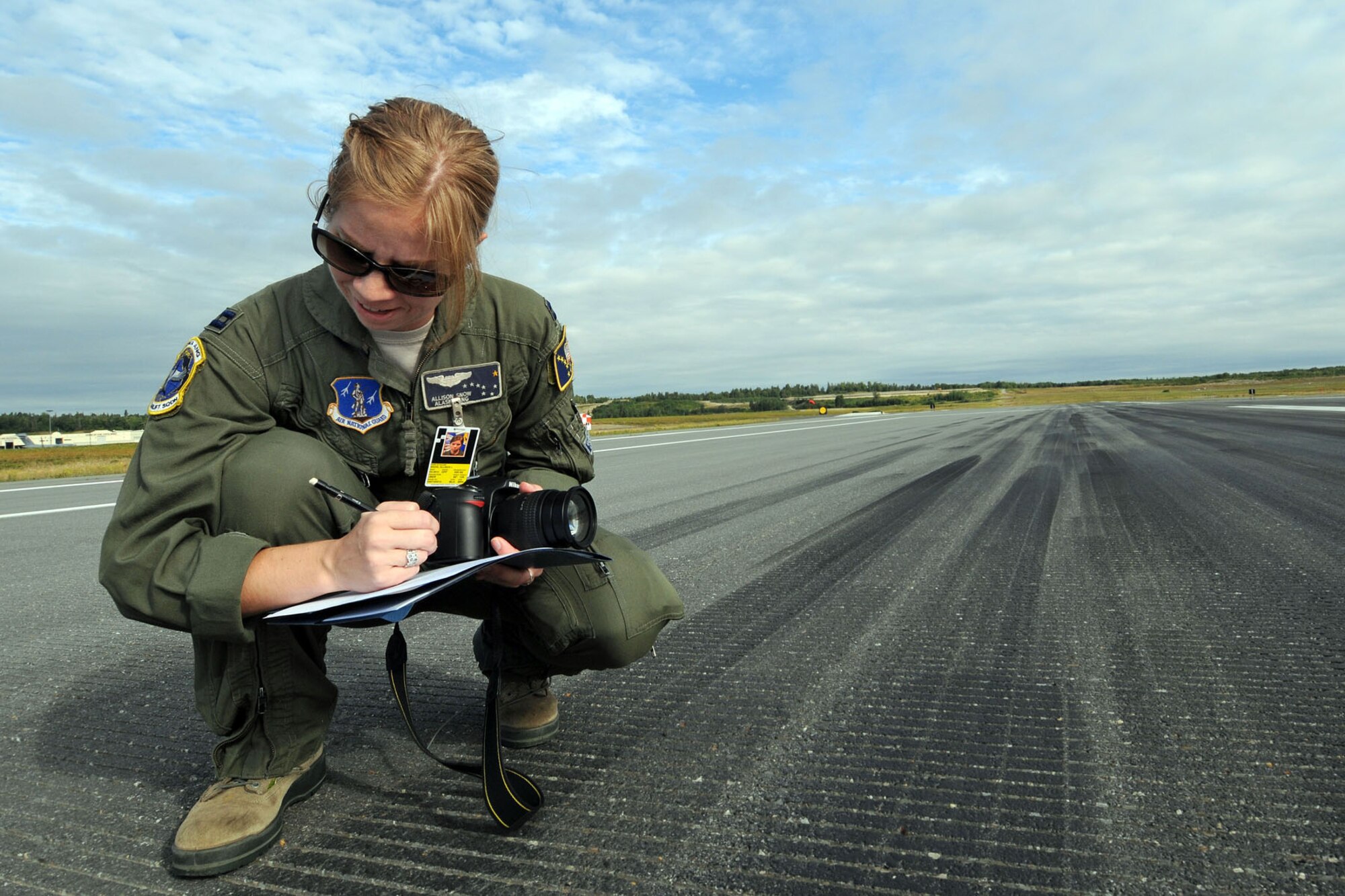 JOINT BASE ELMENDORF-RICHARDSON, Alaska - Capt. Allison Snow, a C-17 pilot with the Alaska Air National Guard's 249th Airlift Squadron measures the accuracy of a C-17 landing on the flight line here Aug. 11, 2012. Snow was a lead judge for aircraft landings in a "Moose Shoot" -- an airdrop and landing competition between the 176th Wing's airlift squadrons as well as their active-duty Air Force associate units, the 517th and 537th airlift squadrons. (National Guard Photo by Tech. Sgt. Jennifer Theulen)