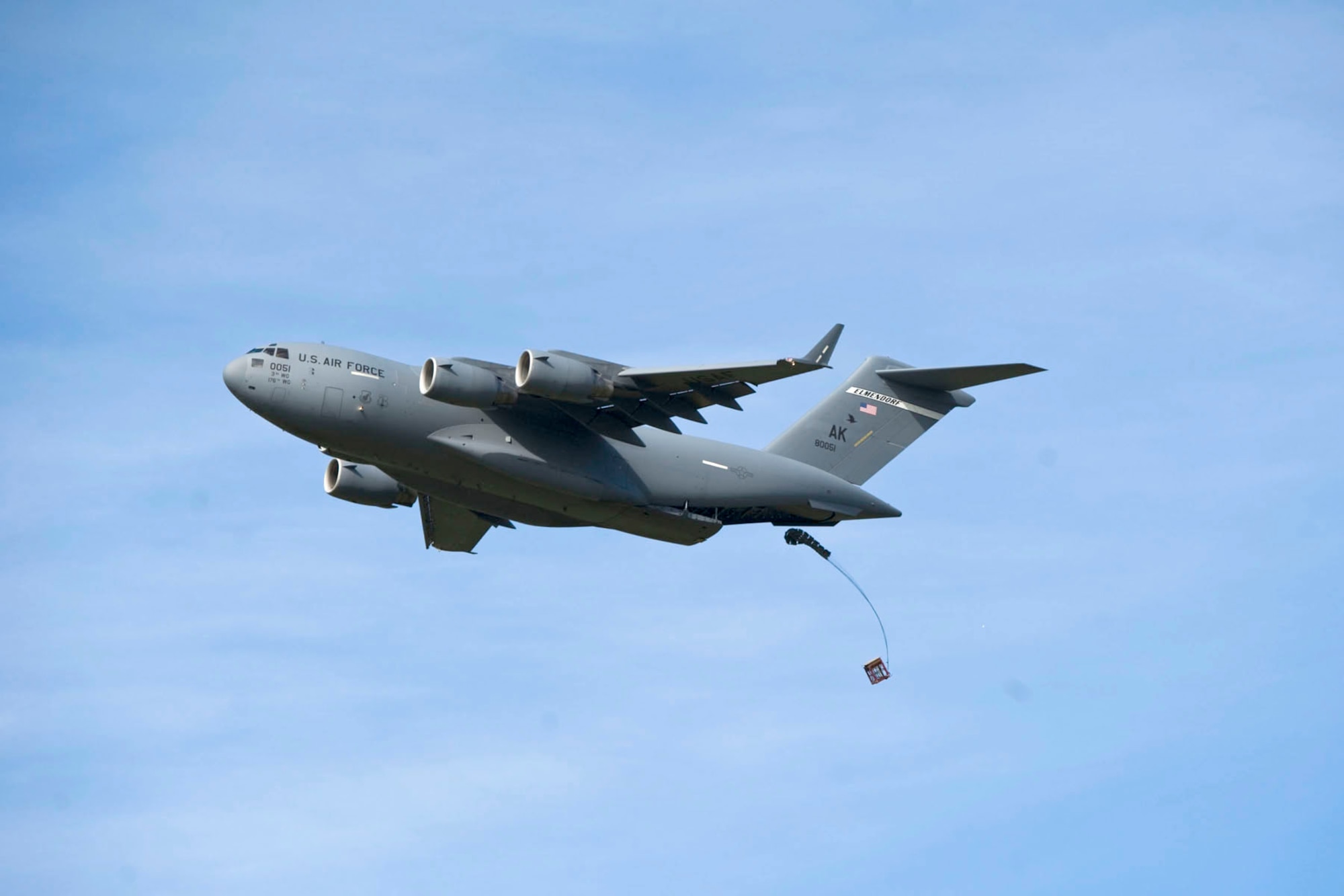 JOINT BASE ELMENDORF-RICHARDSON, Alaska - A C-17 drops a training container delivery system at the Malamute Drop Zone here Aug. 11, 2012. The Aircraft was participating in a "Moose Shoot" -- an airdrop and landing competition between the 176th Wing's airlift squadrons as well as their active-duty Air Force associate units, the 517th and 537th airlift squadrons.  (National Guard photo by Master Sgt. Shannon Oleson)