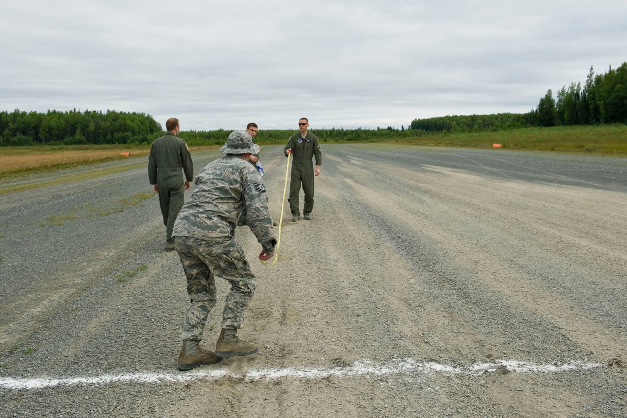 JOINT BASE ELMENDORF-RICHARDSON, Alaska - An Alaska Air National Guard ground crew measures the accuracy of a C-130?s landing at the Malamute Drop Zone here Aug. 11, 2012. The crew and the aircraft were participating in a "Moose Shoot" -- an airdrop and landing competition between the 176th Wing?s airlift squadrons as well as their active-duty Air Force associate units, the 517th and 537th airlift squadrons.  (National Guard photo by Master Sgt. Shannon Oleson)