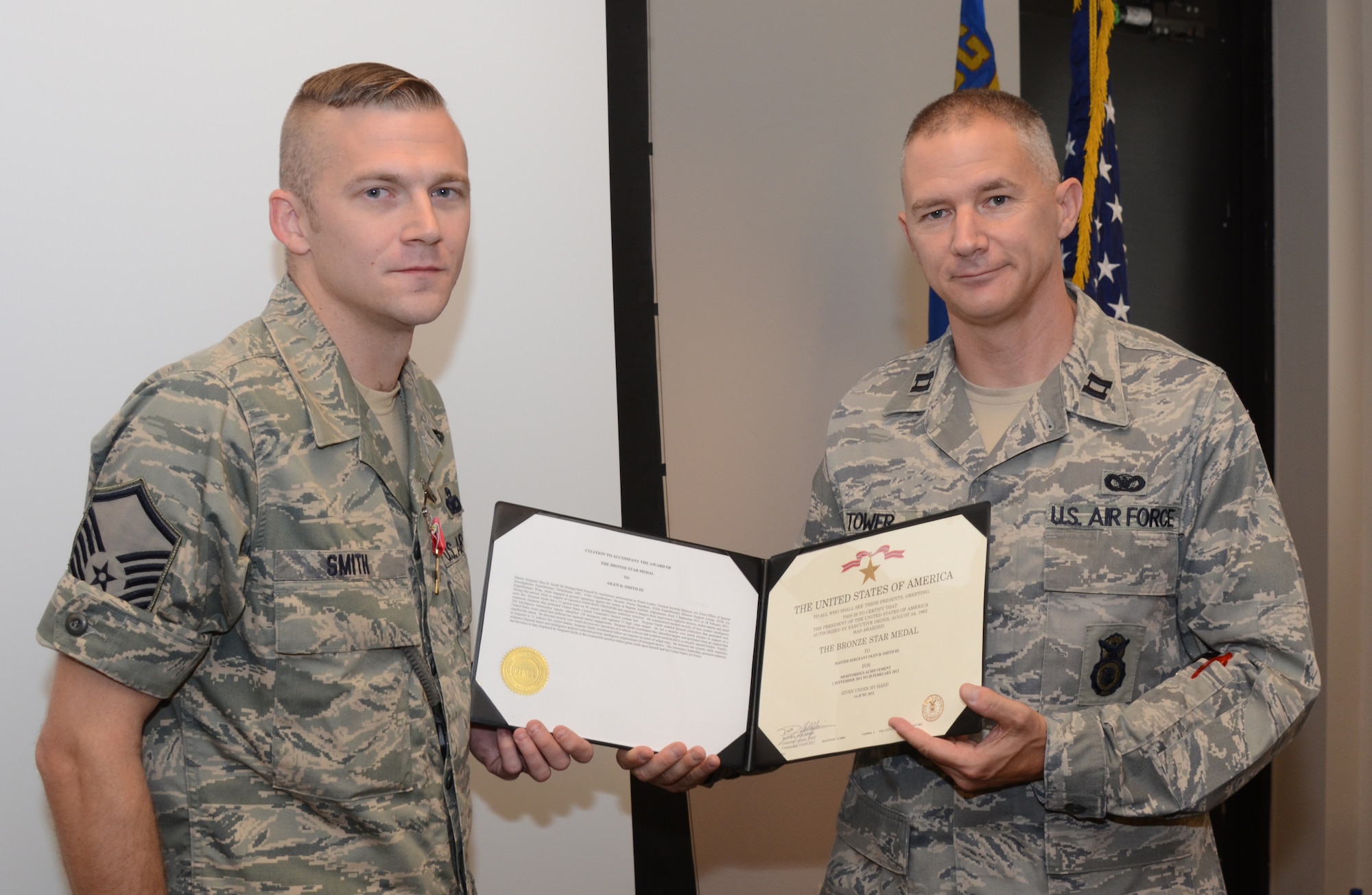 Captain Matthew Tower, commander 175th Security Forces Squadron, presents Master Sgt. Olen D. Smith III, 175th Security Forces Squadron, with the certificate for the Bronze Star Medal.  Smith was presented the award on August 12, 2012 at Warfield Air National Guard Base for his duty in Bagram, Afghanistan. (National Guard photo by TSgt. Chris Schepers)