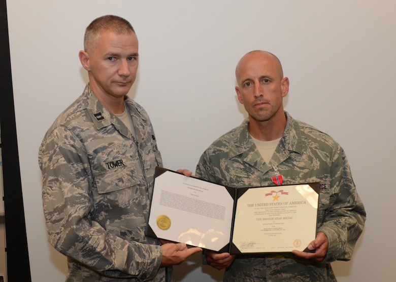 Captain Matthew Tower, commander 175th Security Forces Squadron, presents Master Sgt. John Duly, 175th Security Forces Squadron, with the certificate for the Bronze Star Medal.  Duly was presented the award on August 12, 2012 at Warfield Air National Guard Base for his duty in Bagram, Afghanistan.  (National Guard photo by TSgt. Chris Schepers)