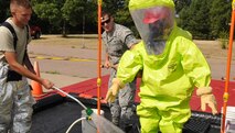 Staff Sgt. David Cooper, a member of the 185th Air Refueling Wing’s Disaster Response Team, steps through the decontamination center during a “White Powder” exercise, August 10, 2012. Members of the 185th worked with the Sioux City Fire Department to test their ability to report, control, test, and remove potentially deadly chemicals. (U.S. Air National Guard Photo by Tech. Sgt. Richard Murphy/ Released)