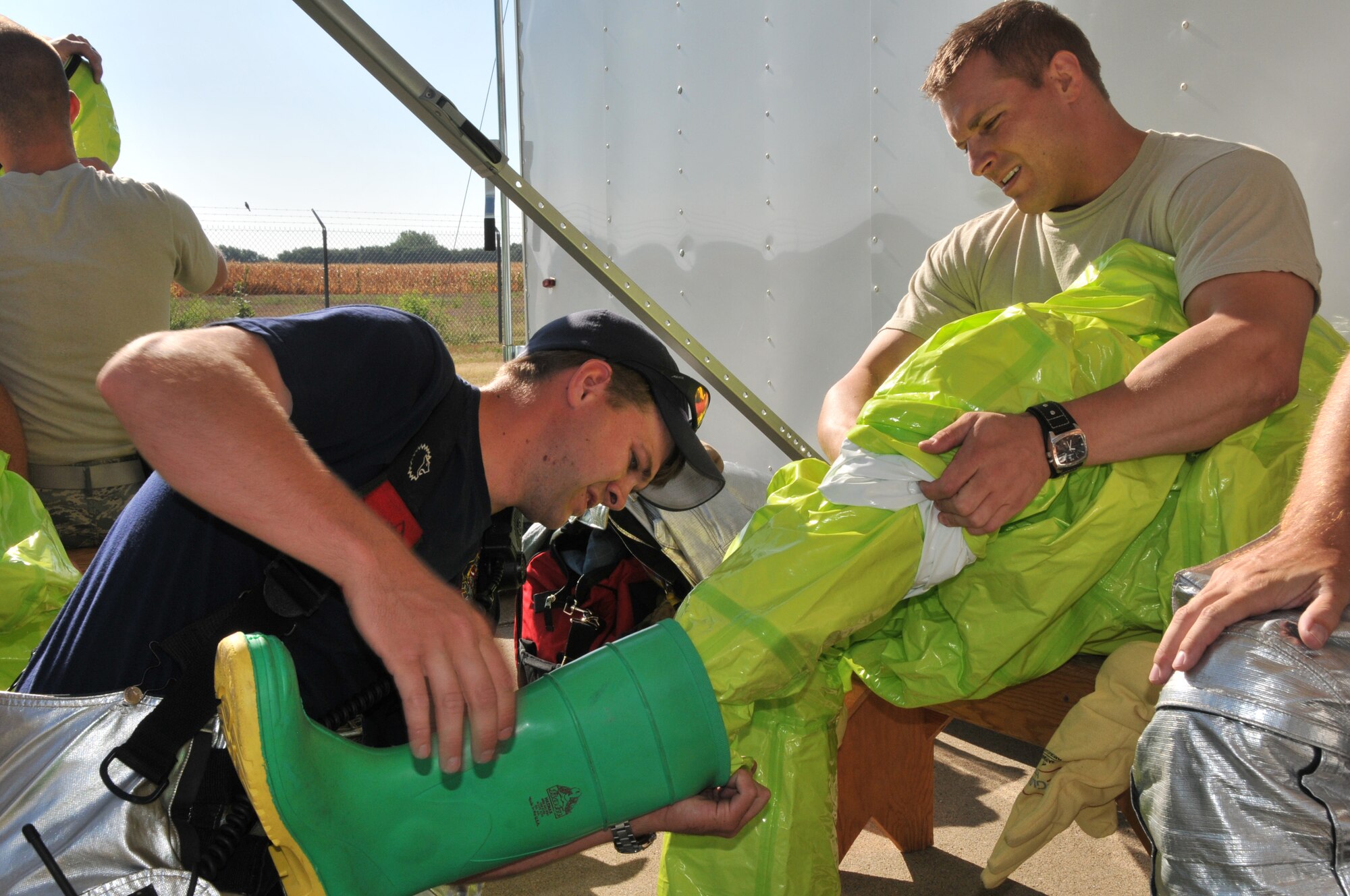 A member of the Sioux City Fire Department (left) assists a member of the 185th Air Refueling Wing, Iowa Air National Guard, in donning a chemical suit during a “White Powder” exercise, August 10, 2012. Members of the 185th worked with the Sioux City Fire Department to test their ability to report, control, test, and remove potentially deadly chemicals. (U.S. Air National Guard Photo by Tech. Sgt. Richard Murphy/ Released)