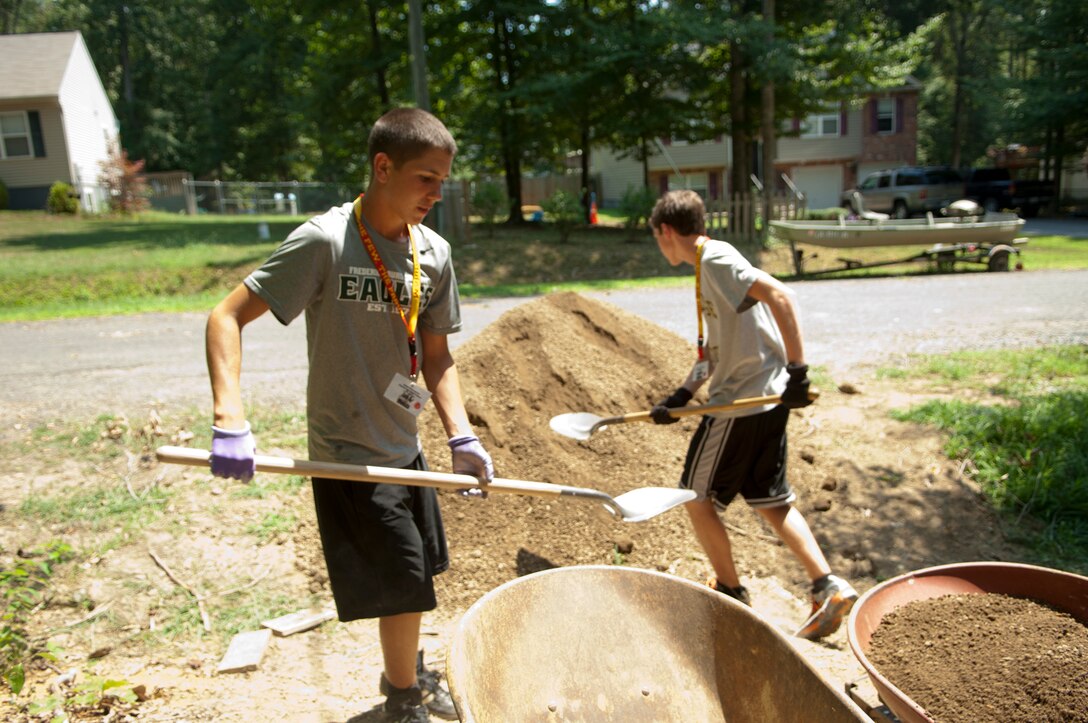 High school students Ian Woods (left) and James Sullivan (right) shovel dirt into wheel barrows while participating in a community service project for Habitat for Humanity while attending the Summer Leadership and Character Development Academy, Thursday. The SLCDA is a week-long camp designed to teach high school students from around the country the skills necessary to be successful leaders. 