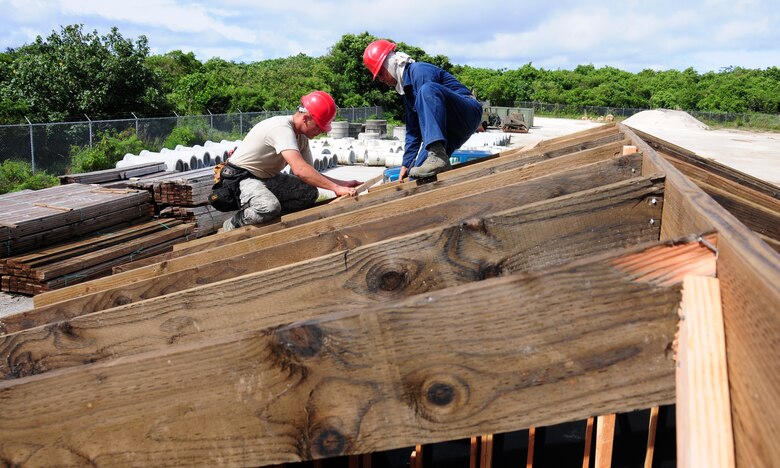 ANDERSEN AIR FORCE BASE, Guam— Two members of the 554th REDHORSE Squadron work together to frame a roof during structural framing training here July 30. When deployed, members of the 554th RHS are required to build large structures constructed out of wooden materials. Training that Airmen receive will allow them to know the basics before being required to build down range. (U.S. Air Force photo by Senior Airman Benjamin Wiseman/Released)