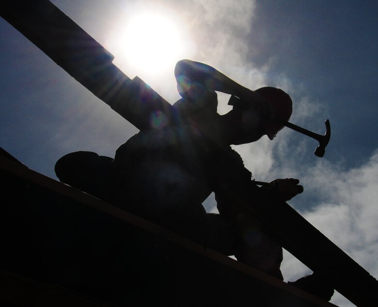 ANDERSEN AIR FORCE BASE, Guam— A member of the 554th REDHORSE Squadron drives a nail as other members frame a building during framing training, July 30. When deployed, members of the 554th RHS are required to build large structures constructed out of wooden materials. Training that Airmen receive will allow them to know the basics before being required to build down range.  (U.S. Air Force photo by Senior Airman Benjamin Wiseman/Released)