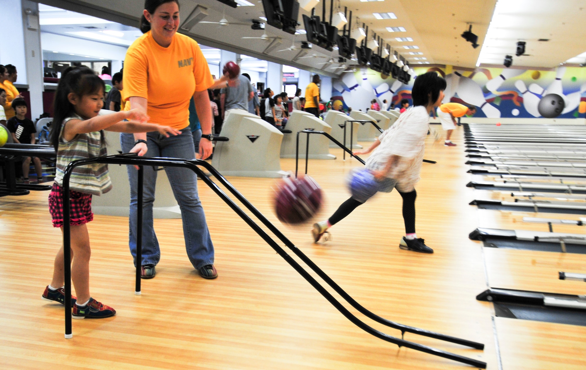 Electronics Technician Seaman Ashley Verones, originally from Westminster, Md., encourages a Japanese student as she takes her turn bowling at the bowling alley at Misawa Air Base, Japan, Aug. 8, 2012. NAF Misawa invited students from Shichinohe Community Center to visit the northern-Japan located U.S. Naval installation. They interacted with Sailors and took part and toured several of the base facilities. (U.S. Navy photo by Mass Communication Specialist 2nd Class Kenneth G. Takada/Released)