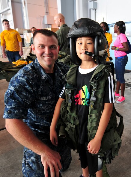 Aircrew Survival Equipmentman 1st Class Brandon Gulley, originally from Pulaski, Tenn. and assigned to Patrol Squadron (VP) 8, poses with a Japanese student after helping him don flight gear at Naval Air Facility Misawa, Japan, Aug. 8, 2012. The students, from Shichinohe Community Center, were invited on board NAF Misawa to interact with Sailors and visit several of the base facilities. (U.S. Navy photo by Mass Communication Specialist 2nd Class Kenneth G. Takada/Released)