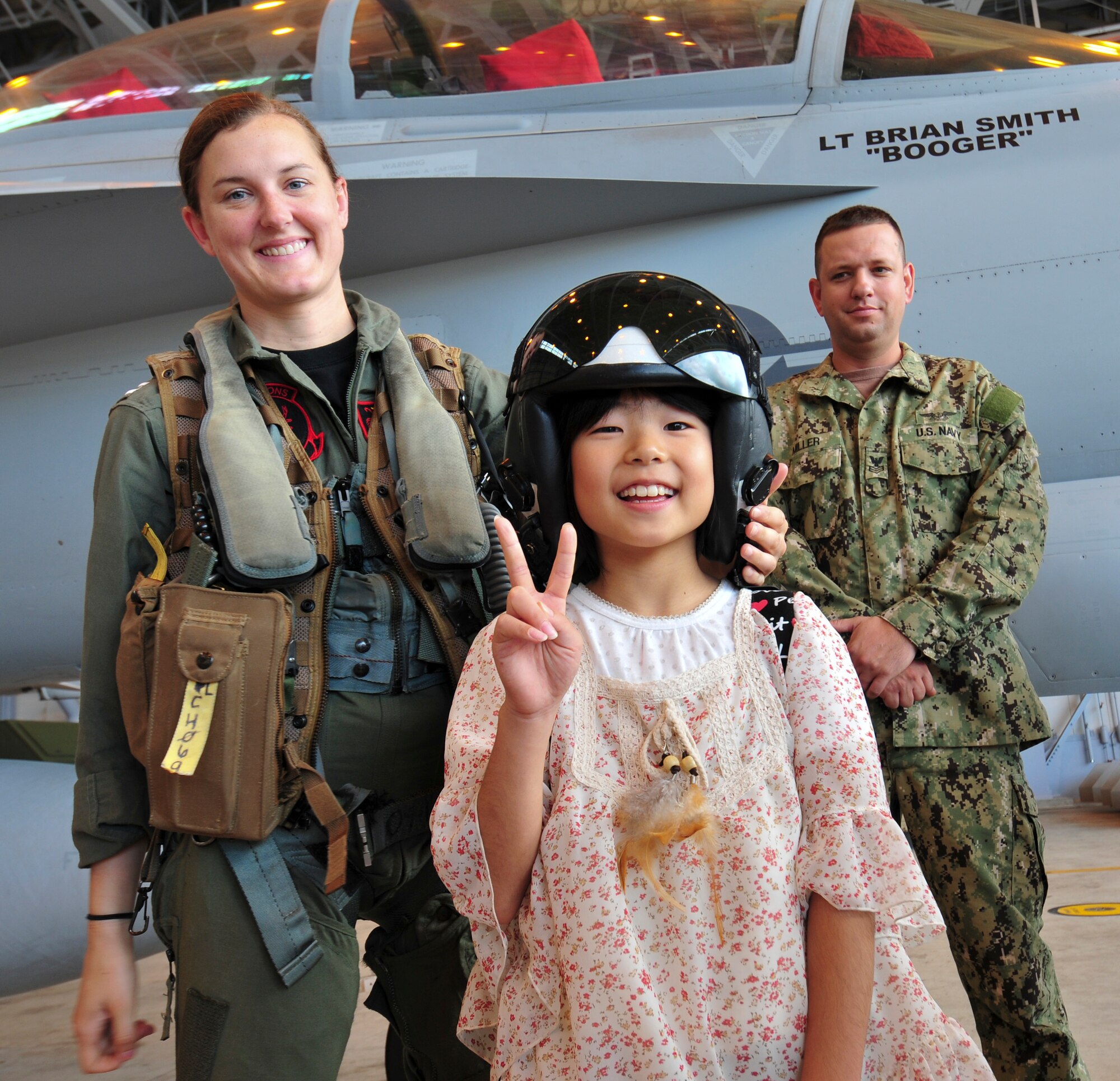 Lt. Laura Combs, an electronic warefare officer assigned to Electronic Attack Squadron (VAQ) 132, originally from Lexington, Ky., poses for a photo with a young fan during a tour of the squadron hangar at Naval Air Facility Misawa, Japan, Aug. 8, 2012. Students from Shichinohe Community Center were invited on board NAF Misawa to interact with Sailors and visit several of the base facilities. (U.S. Navy photo by Mass Communication Specialist 2nd Class Kenneth G. Takada/Released)
