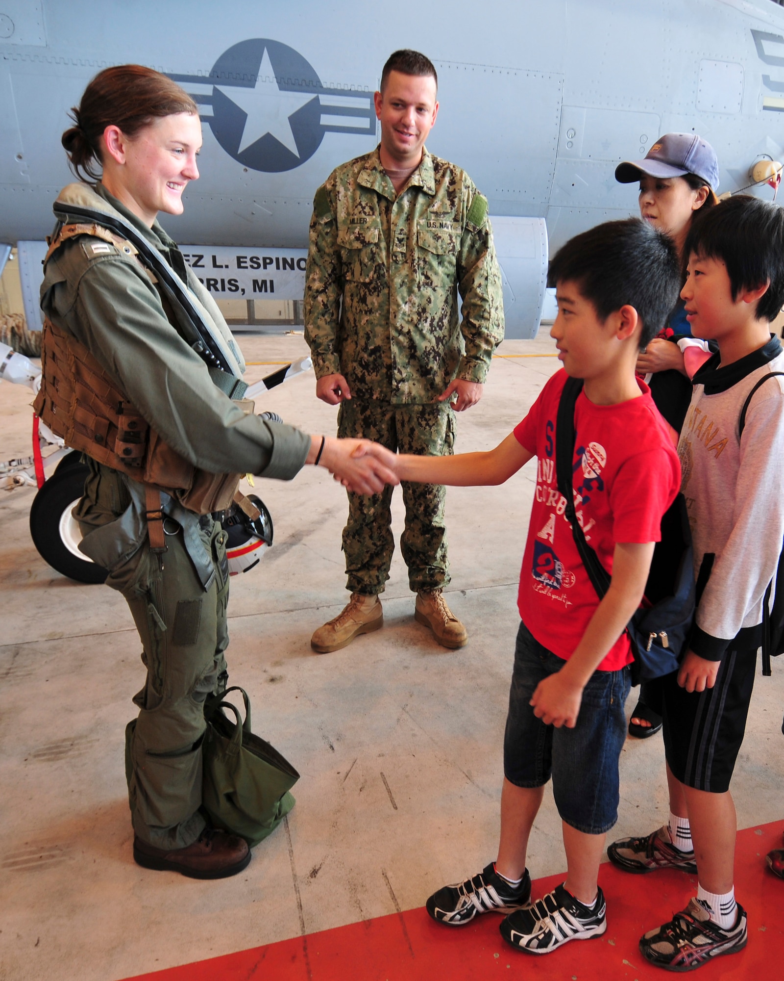 Lt. Laura Combs, an electronic warefare officer assigned to Electronic Attack Squadron (VAQ) 132, originally from Lexington, Ky., shakes hands with a Japanese student during a tour of the squadron hangar at Naval Air Facility Misawa, Japan, Aug. 8, 2012. The students, from Shichinohe Community Center, were invited on board NAF Misawa to interact with Sailors and visit several of the base facilities. (U.S. Navy photo by Mass Communication Specialist 2nd Class Kenneth G. Takada/Released)