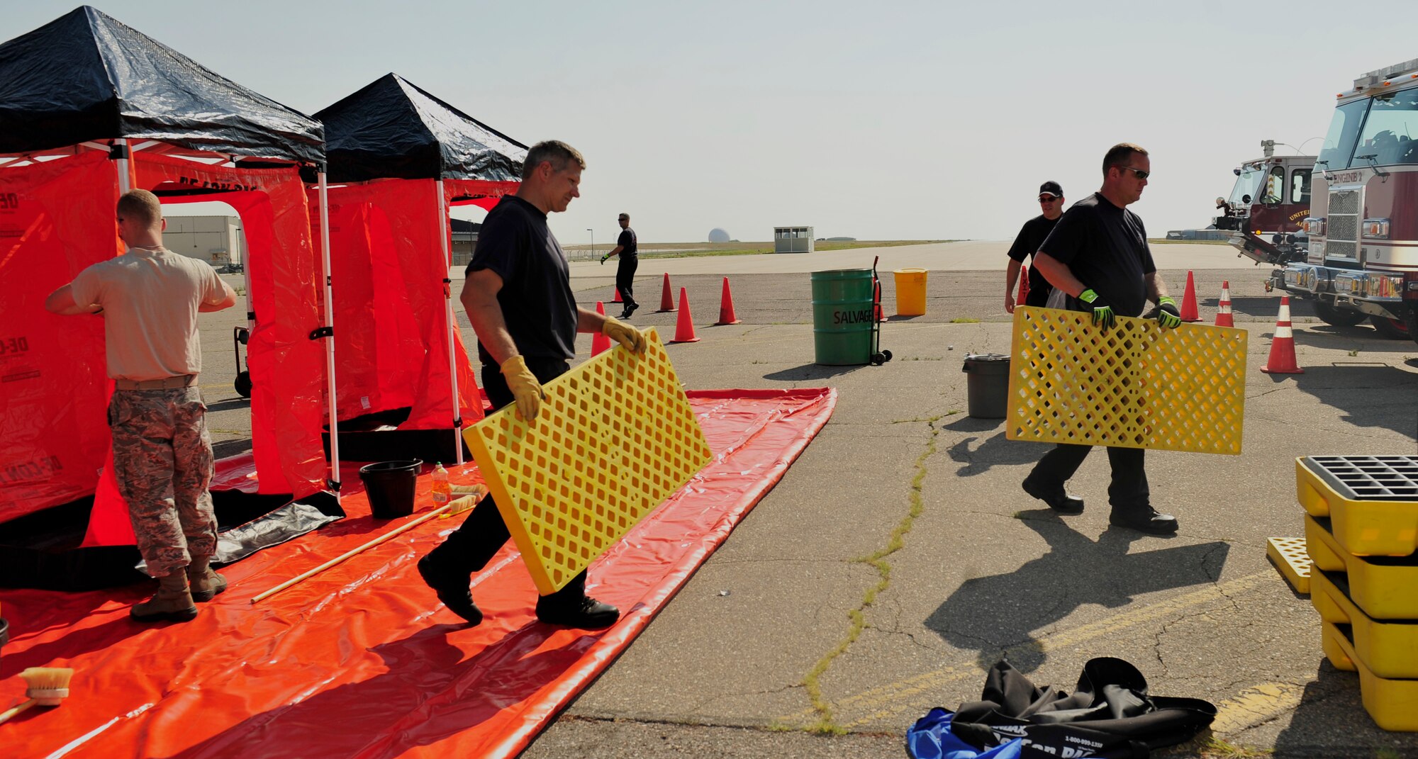BUCKLEY AIR FORCE BASE, Colo. – A group of Buckley Fire Department firefighters prepare to disassemble the de-contamination equipment after their hazardous material training, Aug.  10, 2012. Three wash stations were set up for the training. (U.S. Air Force photo by Airman 1st Class Darryl Bolden Jr)