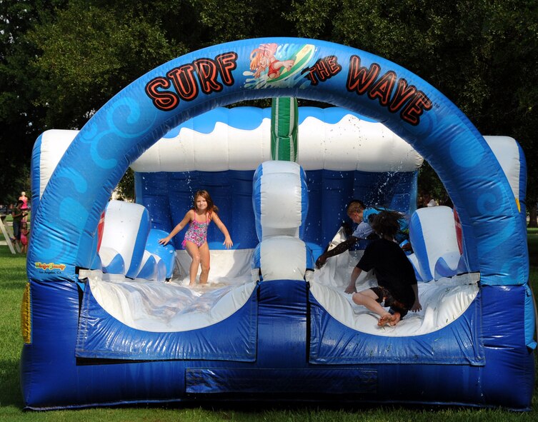 Team Barksdale members run and slide on the Surf The Wave during the annual National Night Out on Barksdale Air Force Base, La., Aug 7. National Night Out is a police hosted event celebrated world-wide on the first Tuesday of August to raise awareness and take a stand against crime. More than 300 participants and volunteers came out to celebrate Barksdale's fifth annual National Night Out. (U.S. Air Force photo/ Senior Airman La'Shanette V. Garrett)(RELEASED)