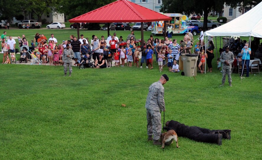 Staff Sgt. Mark Chojnacki and his partner, military working dog Mila, 2nd Security Forces Squadron, perform a search on Senior Airman Demarcus Oguin, 2 SFS, during a controlled aggression K-9 demonstration for the annual National Night Out on Barksdale Air Force Base, La., Aug 7.  The 2 SFS K-9 unit provides trained and certified military working dogs that are capable of tracking, scouting, fighting, guarding and detection.  (U.S. Air Force photo/ Senior Airman La'Shanette V. Garrett)(RELEASED)