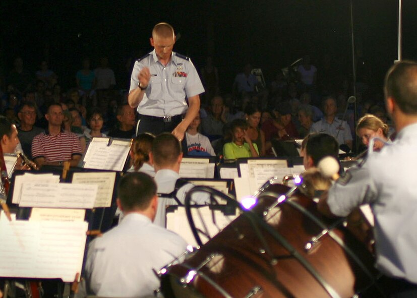 First Lt. Michael Lemoire, U.S. Air Force Honor Guard flight commander, switches roles for an evening and conducts the U.S. Air Force Band during a performance, Aug. 3, at the Air Force Memorial in Arlington Va. Lemoire fulfilled a dream of one day leading the U.S. Air Force Band which he had been aspiring to since his enlistment with the Air Force in 2002. (Courtesy photo by Amelia Harrington)