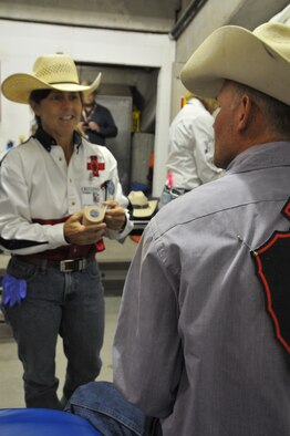 Lt. Col. Julie Resheske, 187th Aeromedical Evacuation Squadron flight nurse, assists a wild horse race contestant with a shoulder wrap before competing at Cheyenne Frontier Days July 25, 2012. Resheske has volunteered with the cowboy medics for 10 years. (U.S. Air Force photo by 1st Lt. Rusty Ridley)




